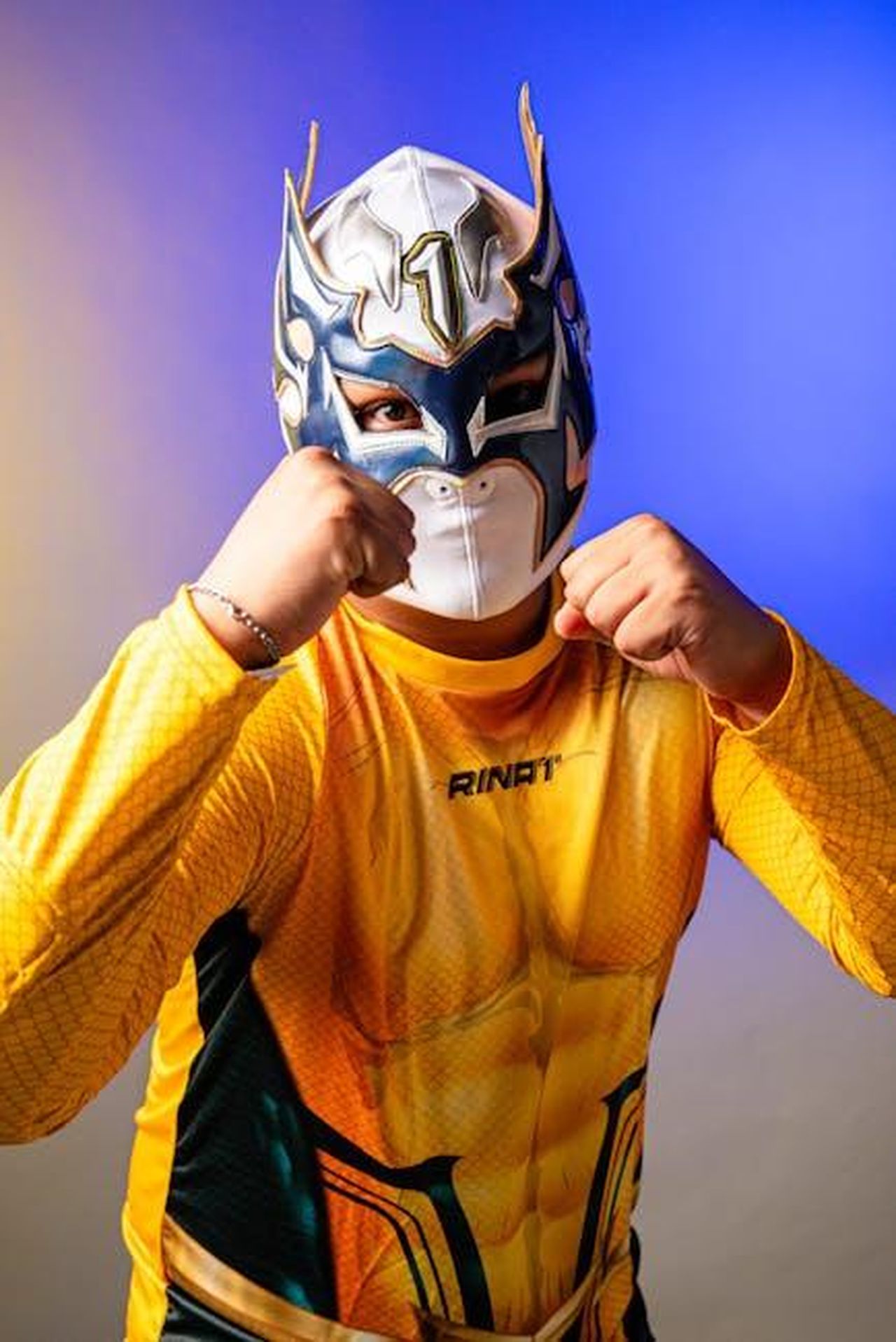 Prevista_una_nuova_eliminazione_dal_cast_del_GF_mt1JCVWGlo - Confidenze24 Source: Jonatan Gomez - pexels - Luchador in vibrant costume strikes a pose, showcasing Mexican wrestling culture.