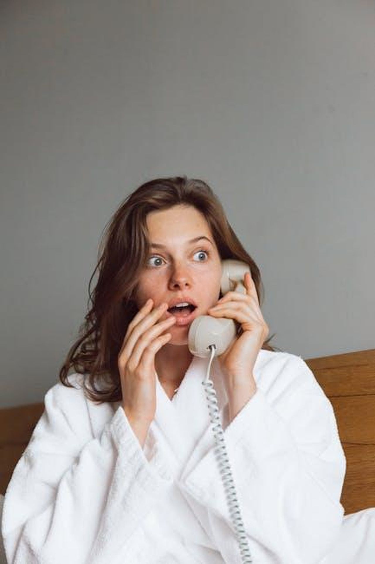 Puntata_di_gioved_27_febbraio_Damiano_felice_per_una_notizia_inaspettata_PJnUATwfxD - Confidenze24 Source: ROMAN ODINTSOV - pexels - A woman in a bathrobe looks shocked while talking on the telephone indoors.