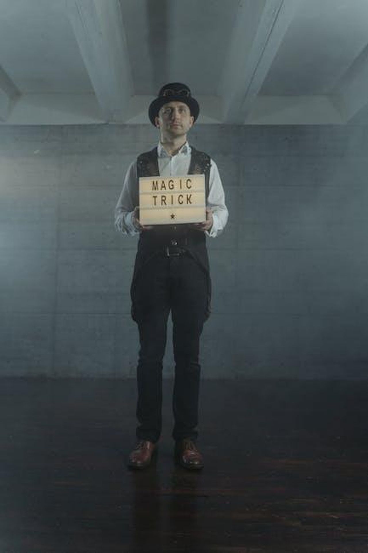 Qual__il_vero_significato_Adil_FuFhUe46ef - Confidenze24 Source: Tima Miroshnichenko - pexels - Magician holding a magic trick sign in a dimly lit room, exuding mystery.