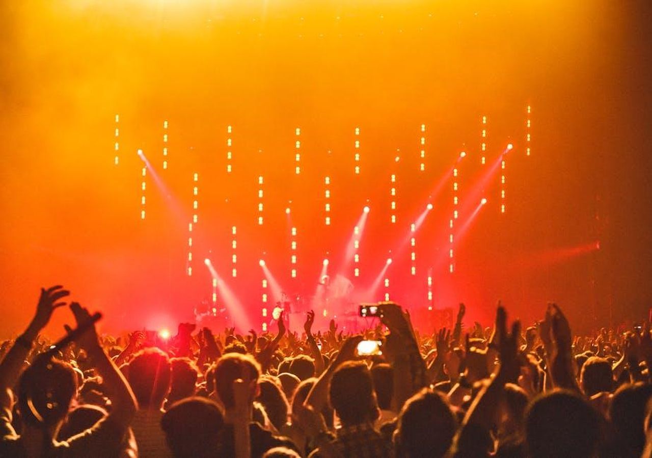 Reazioni_dei_fan_alleliminazione_di_Mollie_FzSsH3dpC7 - Confidenze24 Source: anna-m. w. - pexels - Energetic crowd at a live concert with bright stage lights and hands raised in celebration.