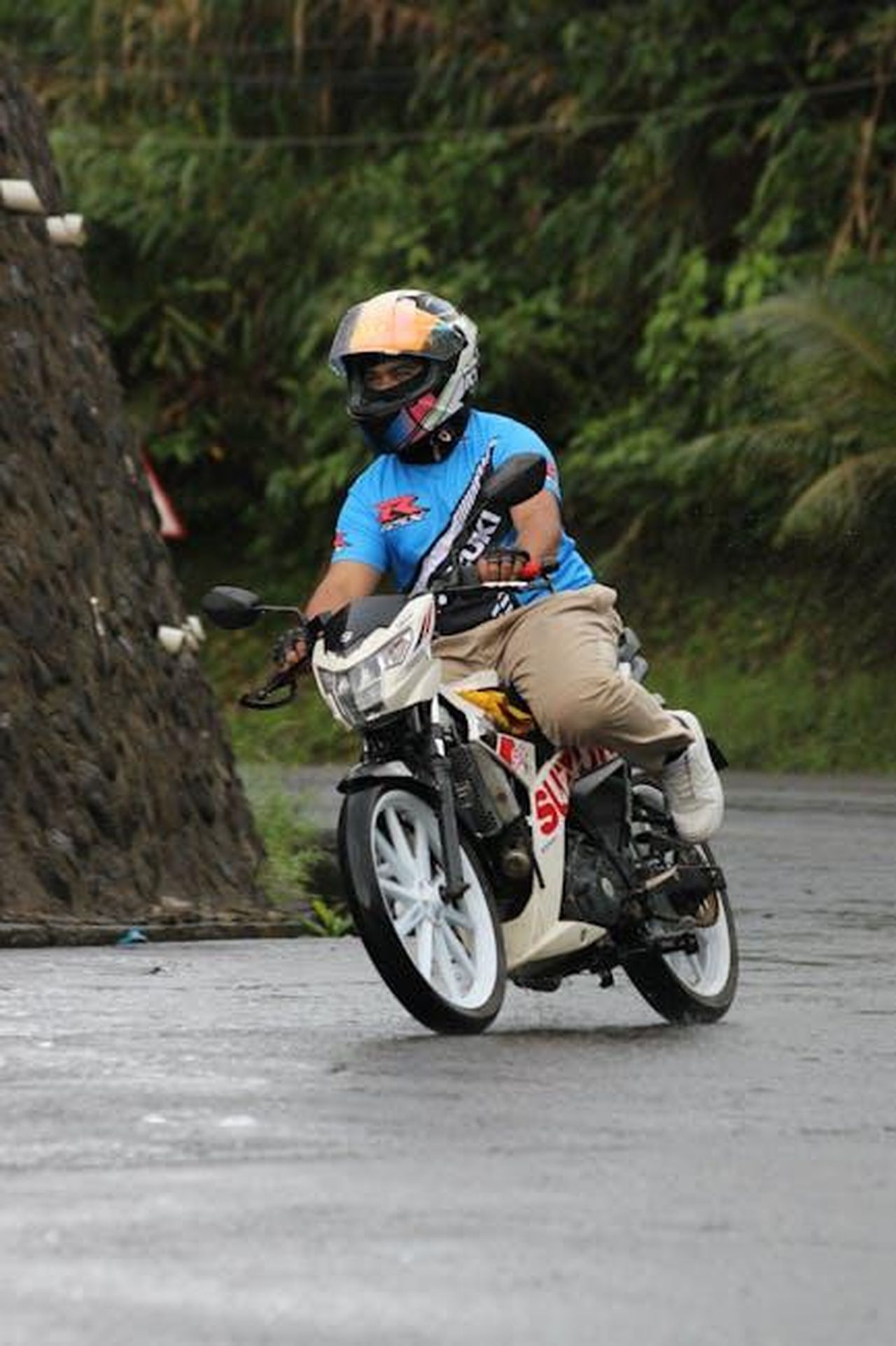Reazioni_e_riflessioni_sulla_sicurezza_WOdQ8qf987 - Confidenze24 Source: Tiwi Riders - pexels - Motorcyclist navigating a wet and winding mountain road, wearing protective gear.