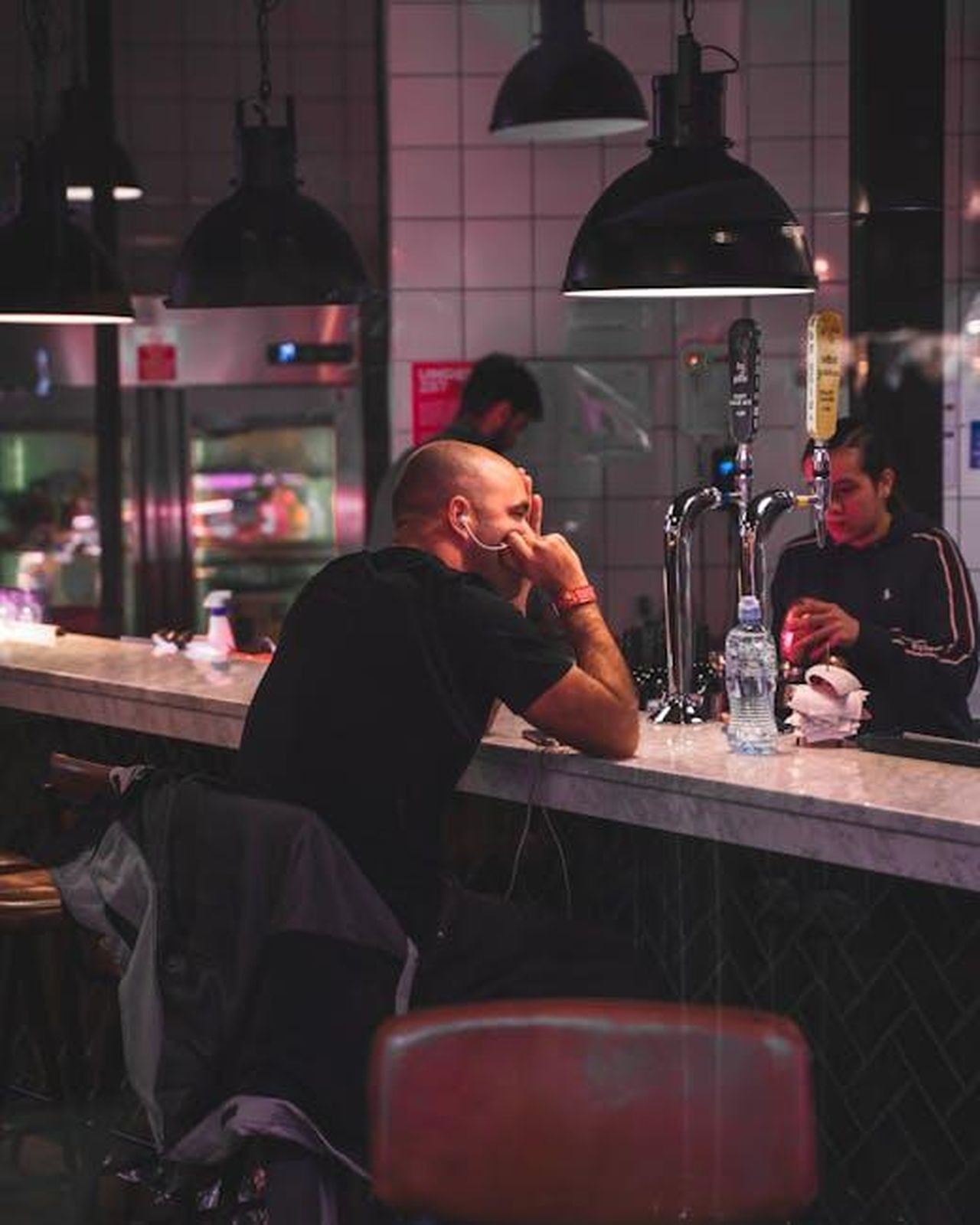 Recensioni_dei_clienti_sulle_lampade_KDG_4Nn71HfeLy - Confidenze24 Source: Connor Danylenko - pexels - A modern bar setting with people enjoying drinks in a cozy ambiance.