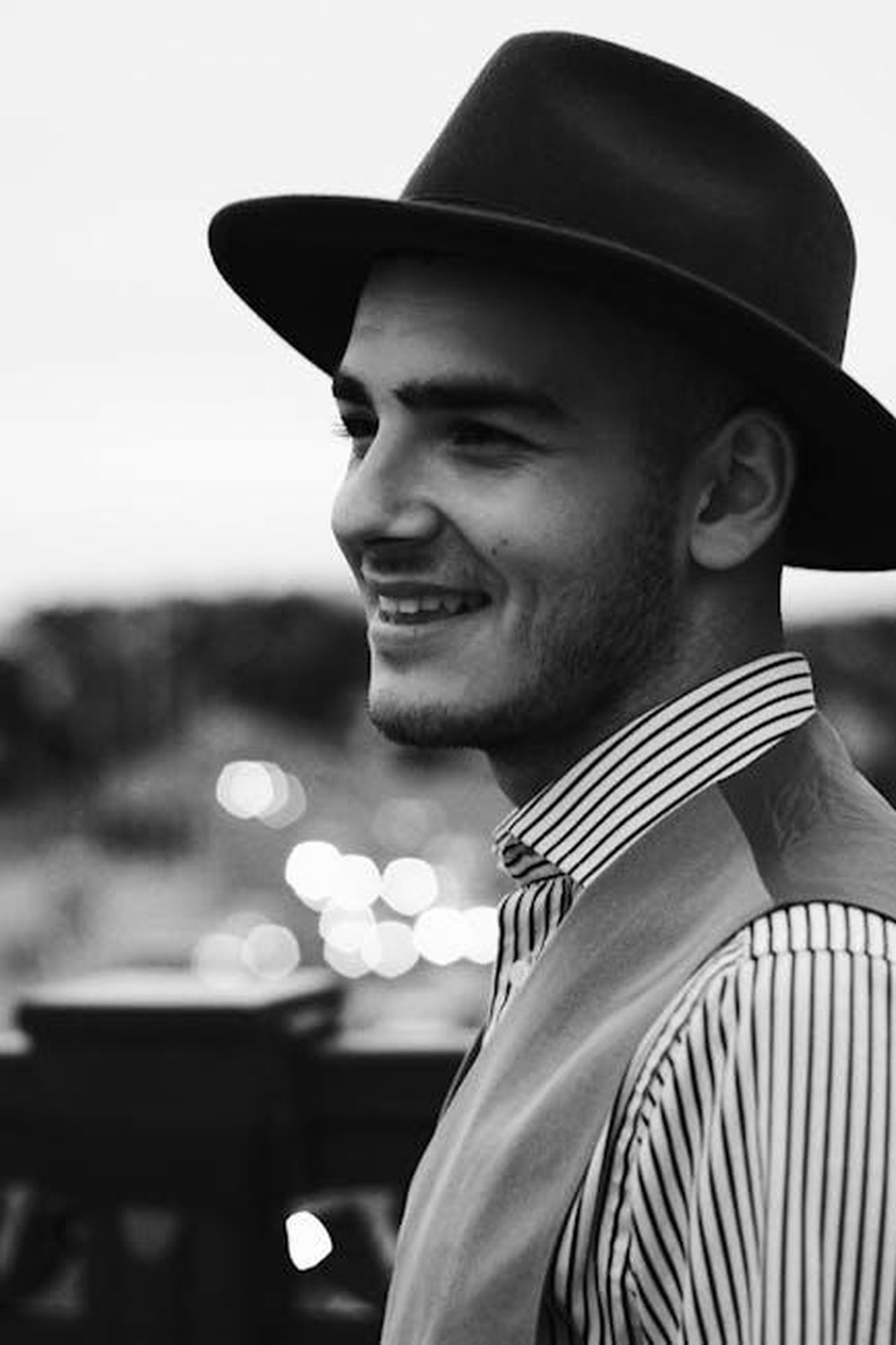 Riepilogo_delle_puntate_precedenti_BXsdkk73yV - Confidenze24 Source: Maksim Goncharenok - pexels - Classic black and white portrait of a smiling man wearing a fedora, capturing a vintage and stylish look.