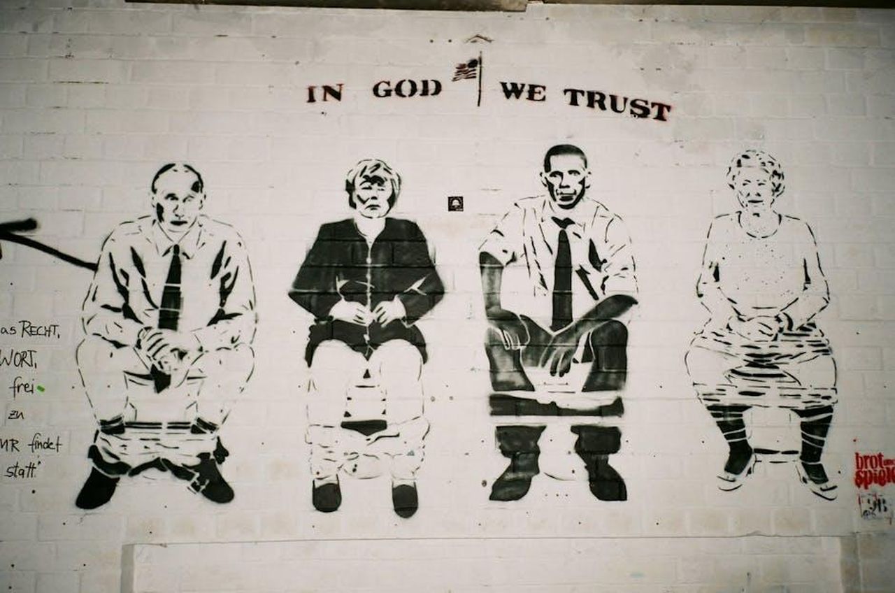 Riflessioni_sul_passato_e_sul_futuro_politico_TqkKdj3alY - Confidenze24 Source: Darya Sannikova - pexels - Satirical street art mural depicting political figures on a brick wall.
