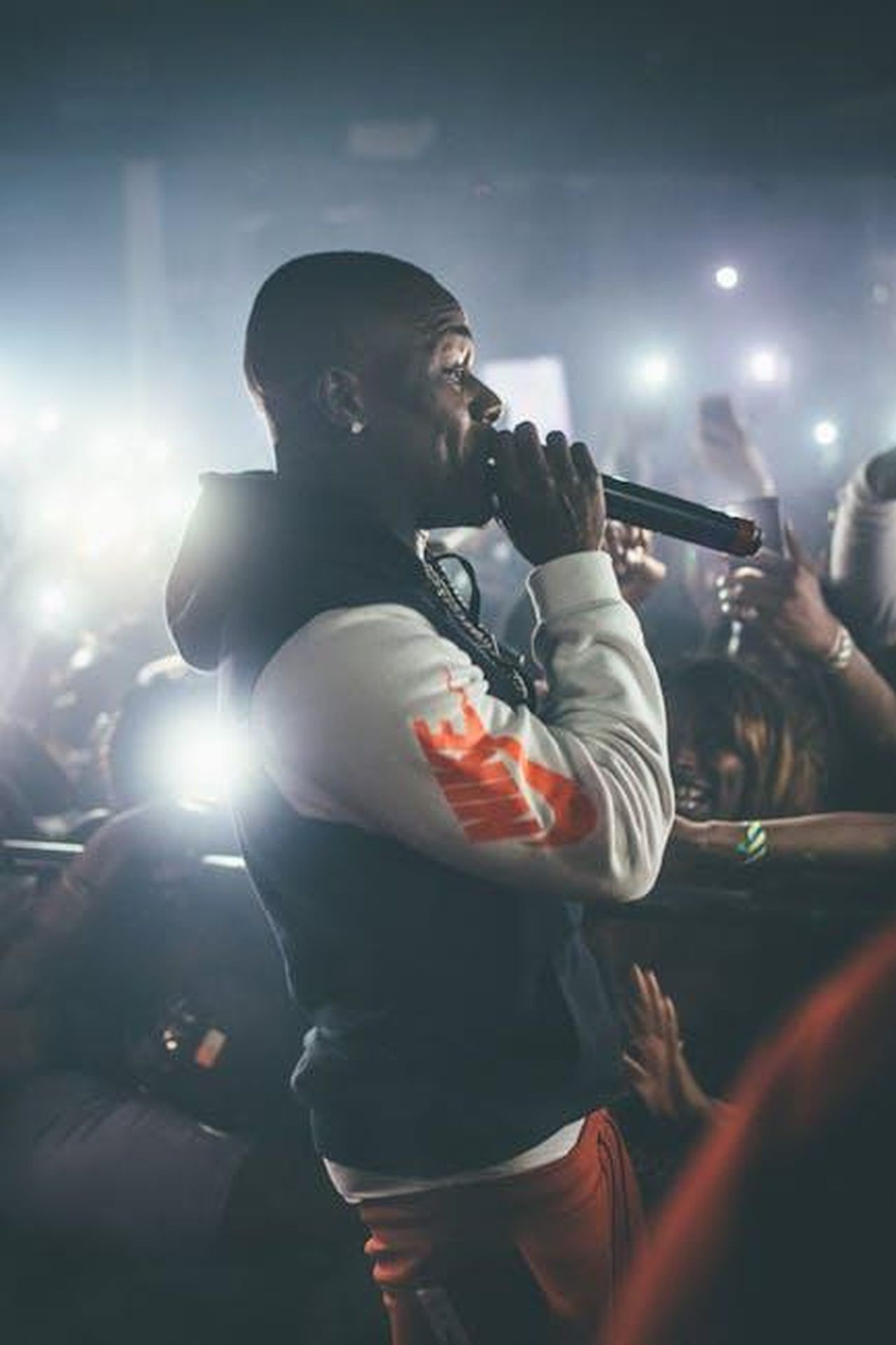 Rinascita_personale_PYR0JM8LCN - Confidenze24 Source: Zachary DeBottis - pexels - Dynamic shot of a rapper performing live in a crowded nightclub with vibrant lights.