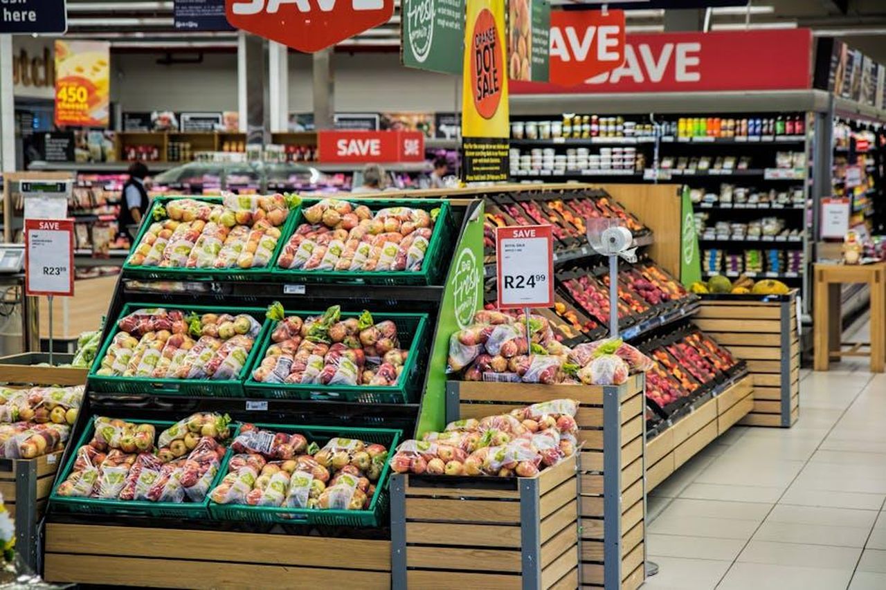 Rita_era_stata_assunta_da_Irene_4R0Rq5gWVC - Confidenze24 Source: Pixabay - pexels - Colorful produce aisle in a supermarket showcasing fresh apples with discount signage.