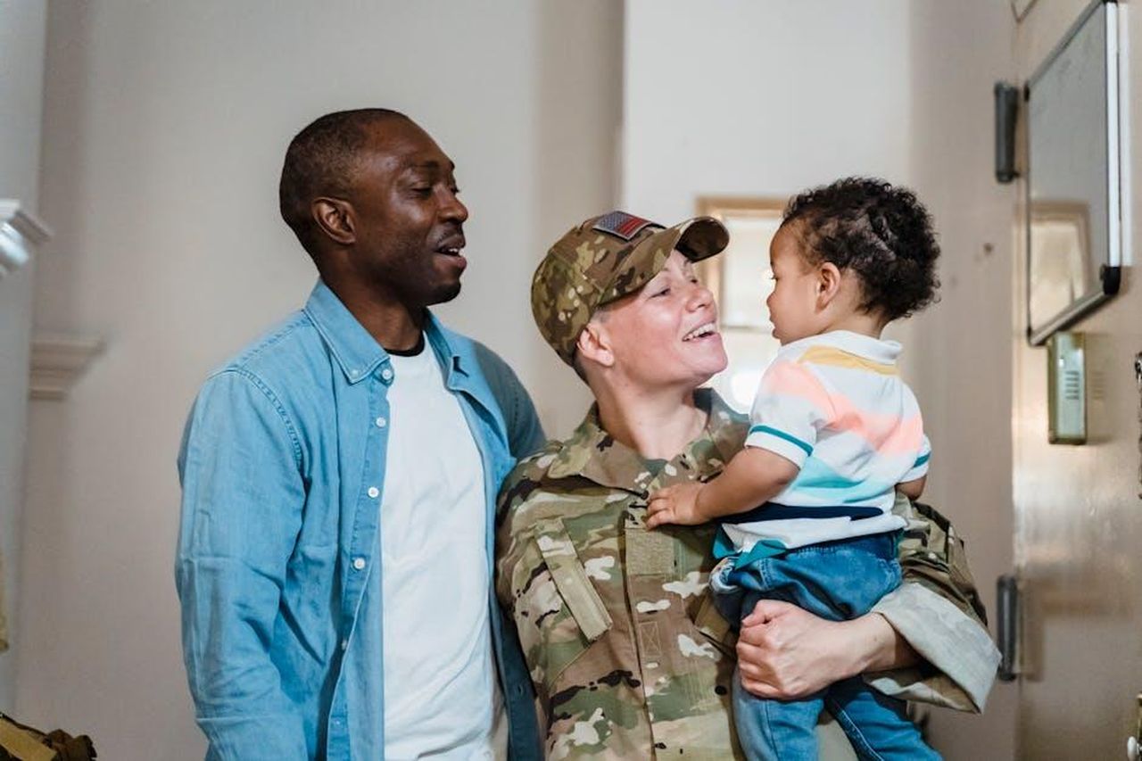 Robert_rinuncia_allofferta_di_lavoro_per_amore_di_Nicole_SZYYb2W6Bj - Confidenze24 Source: George Pak - pexels - Soldier in uniform joyfully reunites with family at home, creating a heartwarming moment.