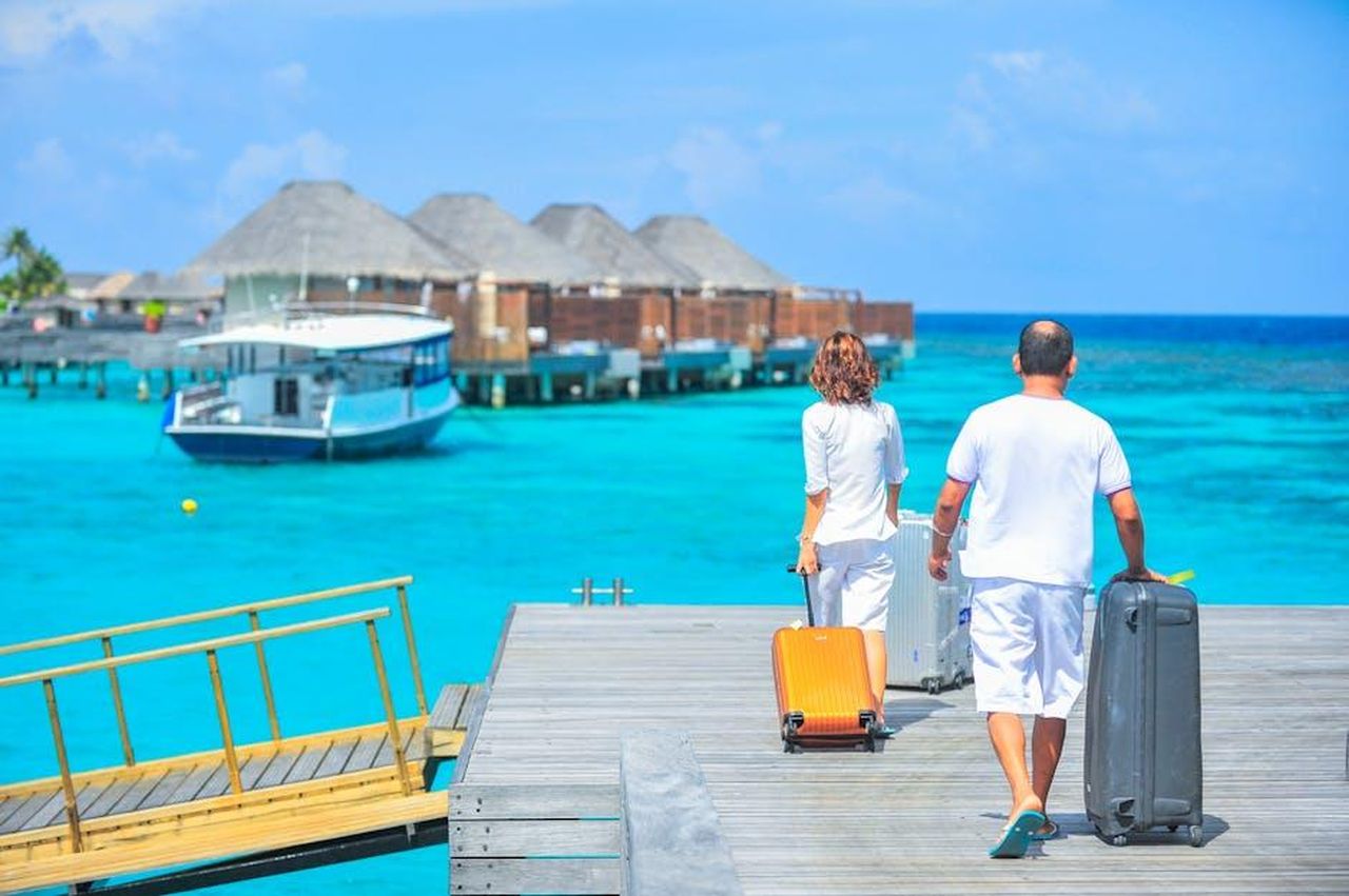 Robert_si_prepara_a_lasciare_il_Frstenhof_G2fge554dF - Confidenze24 Source: Asad Photo Maldives - pexels - A couple arriving at a luxurious Maldives resort dock with luggage, capturing a tropical vacation vibe.