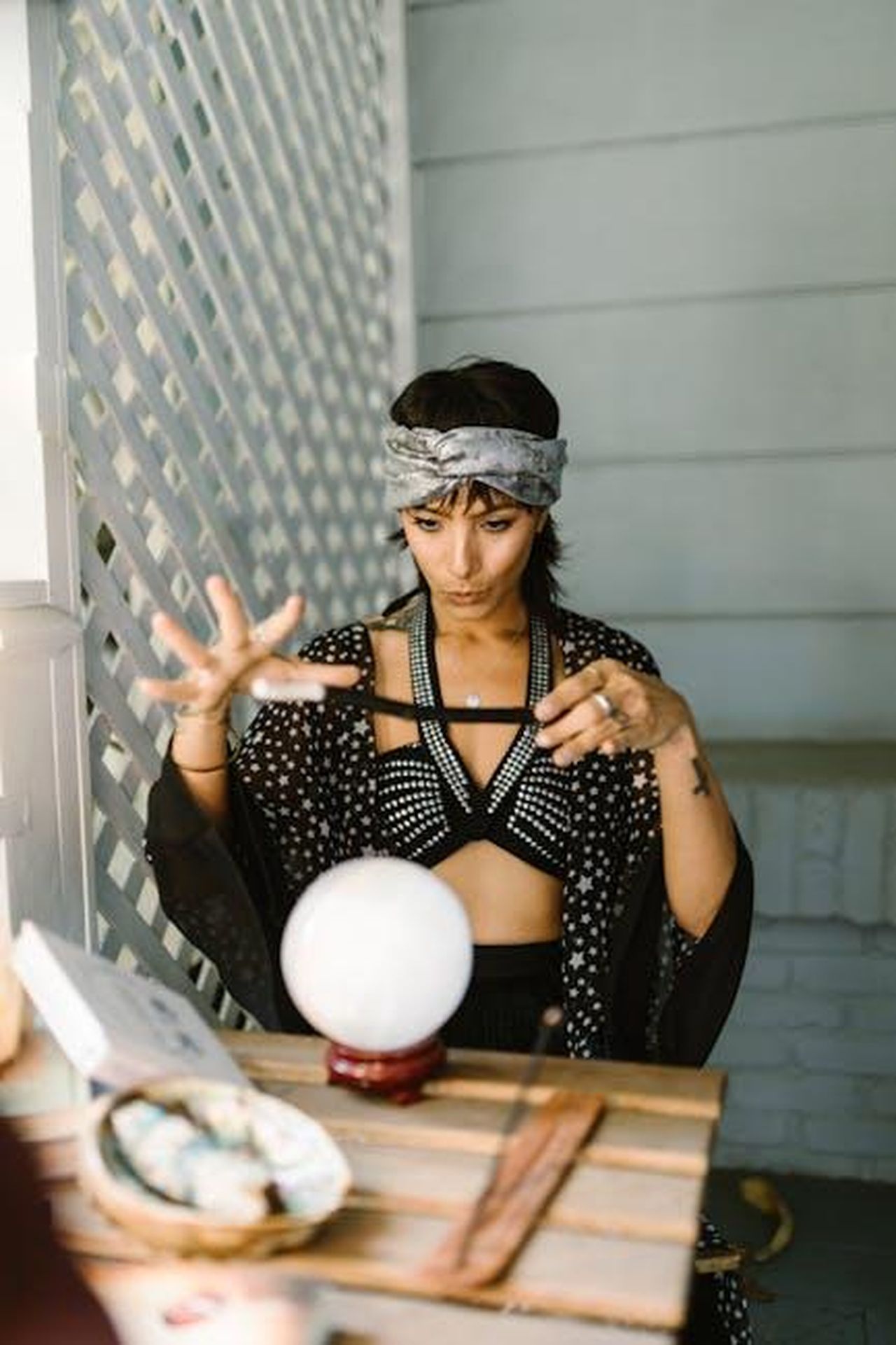 Sagittario_difficolt_e_resilienza_LcJGLpRXwa - Confidenze24 Source: RDNE Stock project - pexels - Mystical woman in patterned attire performing a ritual with crystal ball indoors.