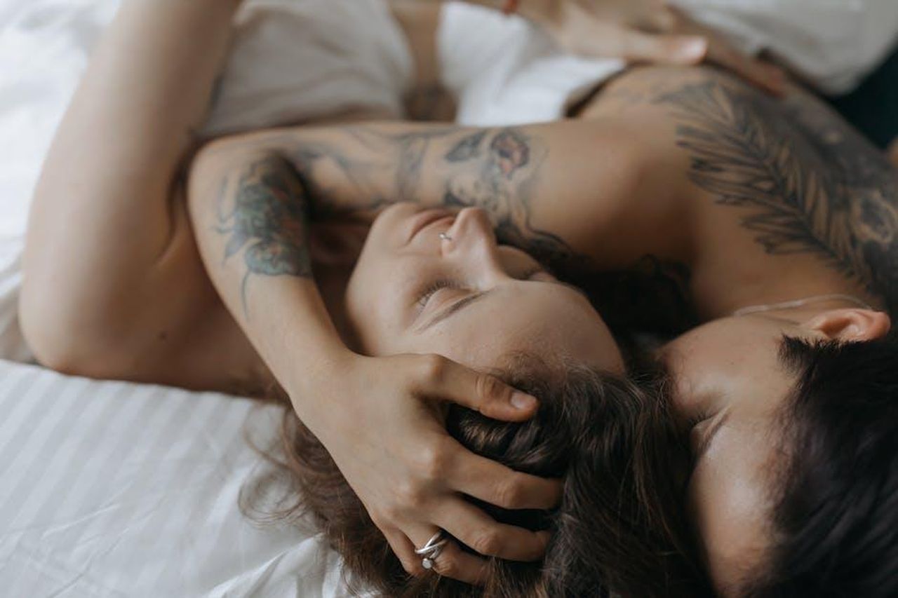 Scorpione_Emozioni_intense_65FPwE4TKn - Confidenze24 Source: cottonbro studio - pexels - Close-up of a loving couple embracing in an intimate moment on a bed, showcasing tattoos and affection.