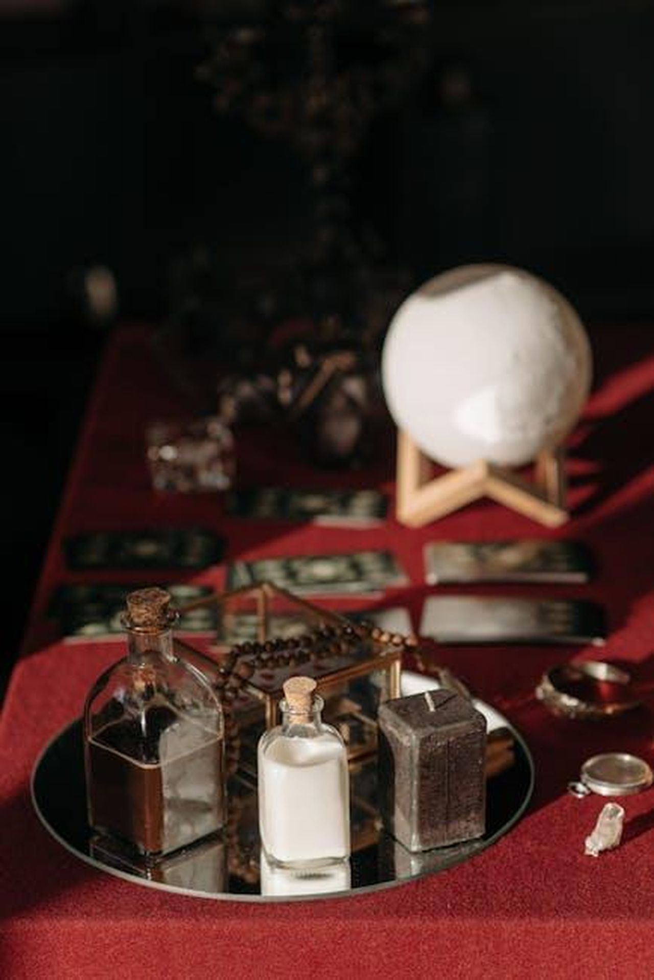 Scorpione__6sdKTIXpZf - Confidenze24 Source: Pavel Danilyuk - pexels - An enchanting fortune telling set with tarot cards, crystal ball, and mystical objects on a red cloth.