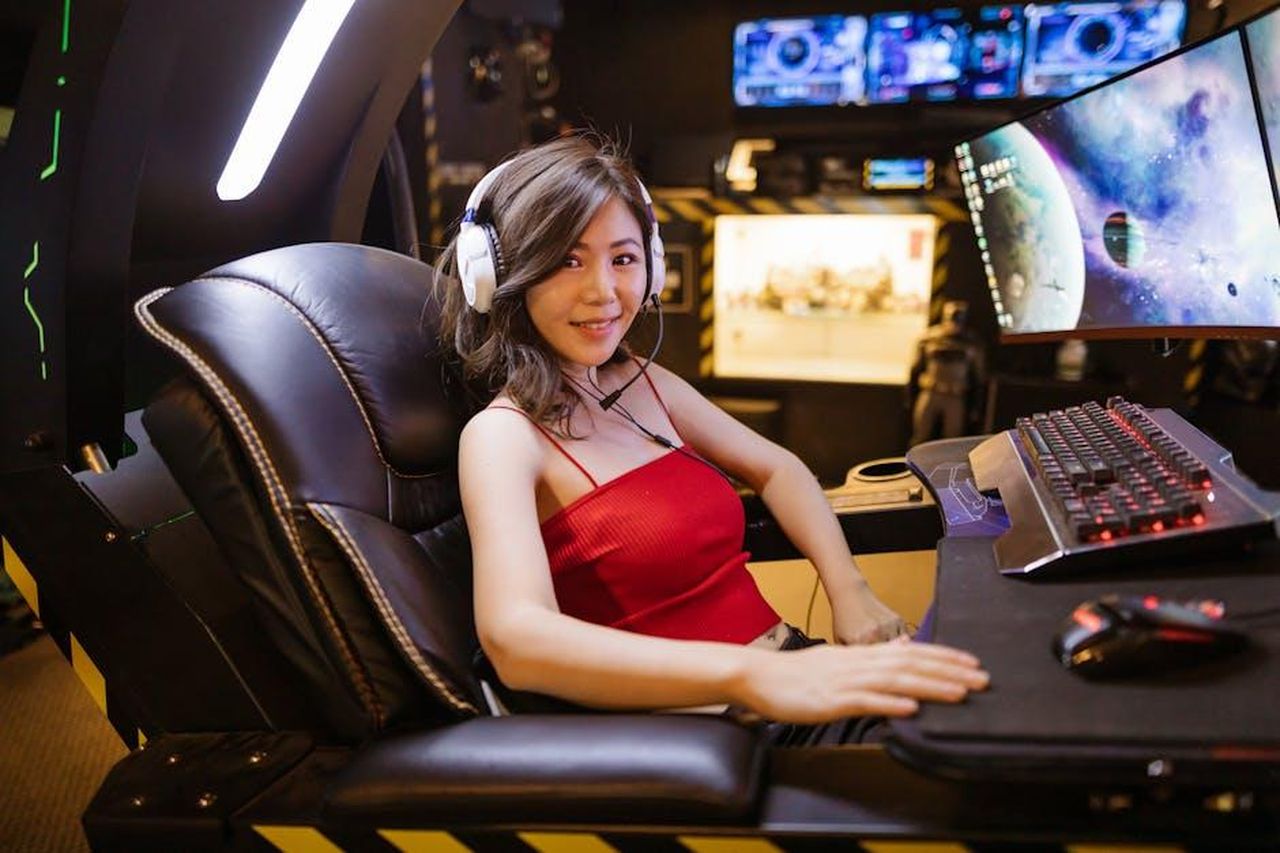 Scorpione_attivi_in_campo_professionale_jtsL6Y5Dp5 - Confidenze24 Source: RDNE Stock project - pexels - A woman seated at an advanced gaming setup featuring a scorpion gaming chair, multiple monitors, and gaming peripherals.