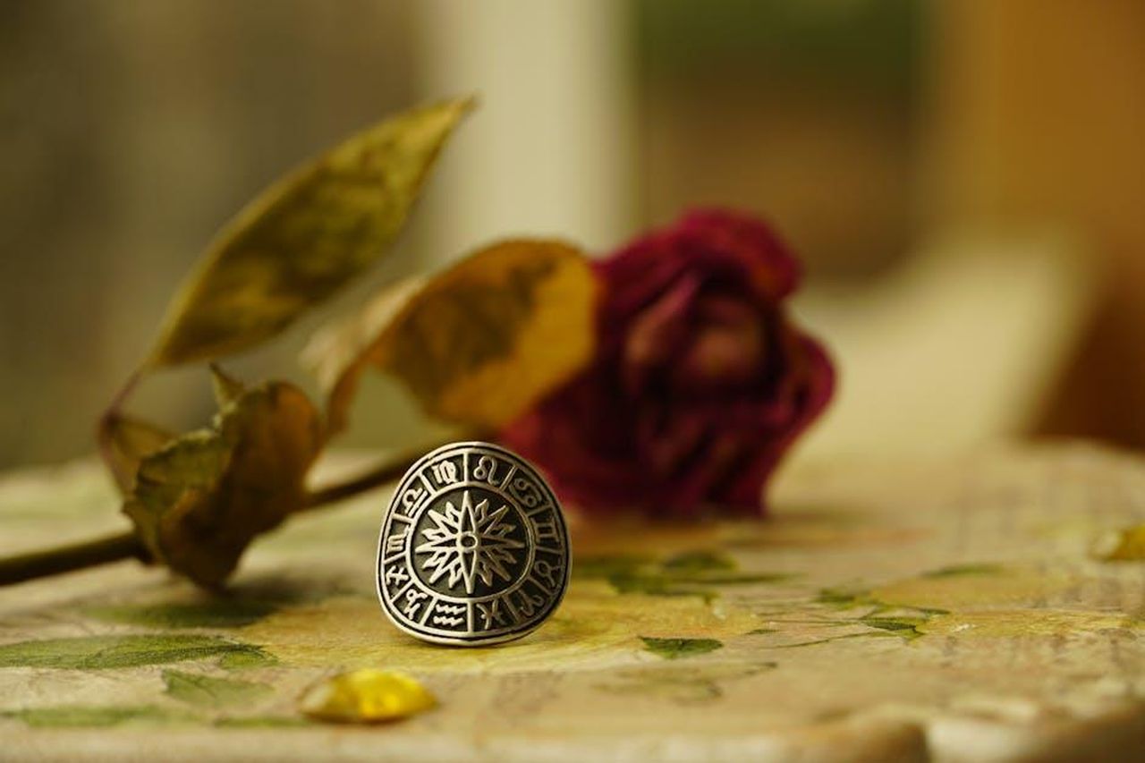 Scorpione_liberarsi_del_peso_NcR22iBSWJ - Confidenze24 Source: Nadejda Bostanova - pexels - Close-up of a zodiac-themed ring with dried flowers in a warm, artistic setting.