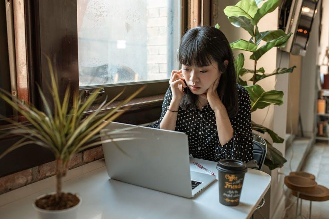 Sedi_disponibili_gY0U1X2e9s - Confidenze24 Source: RDNE Stock project - pexels - Asian woman focused on work in a modern office setting with laptop and coffee.