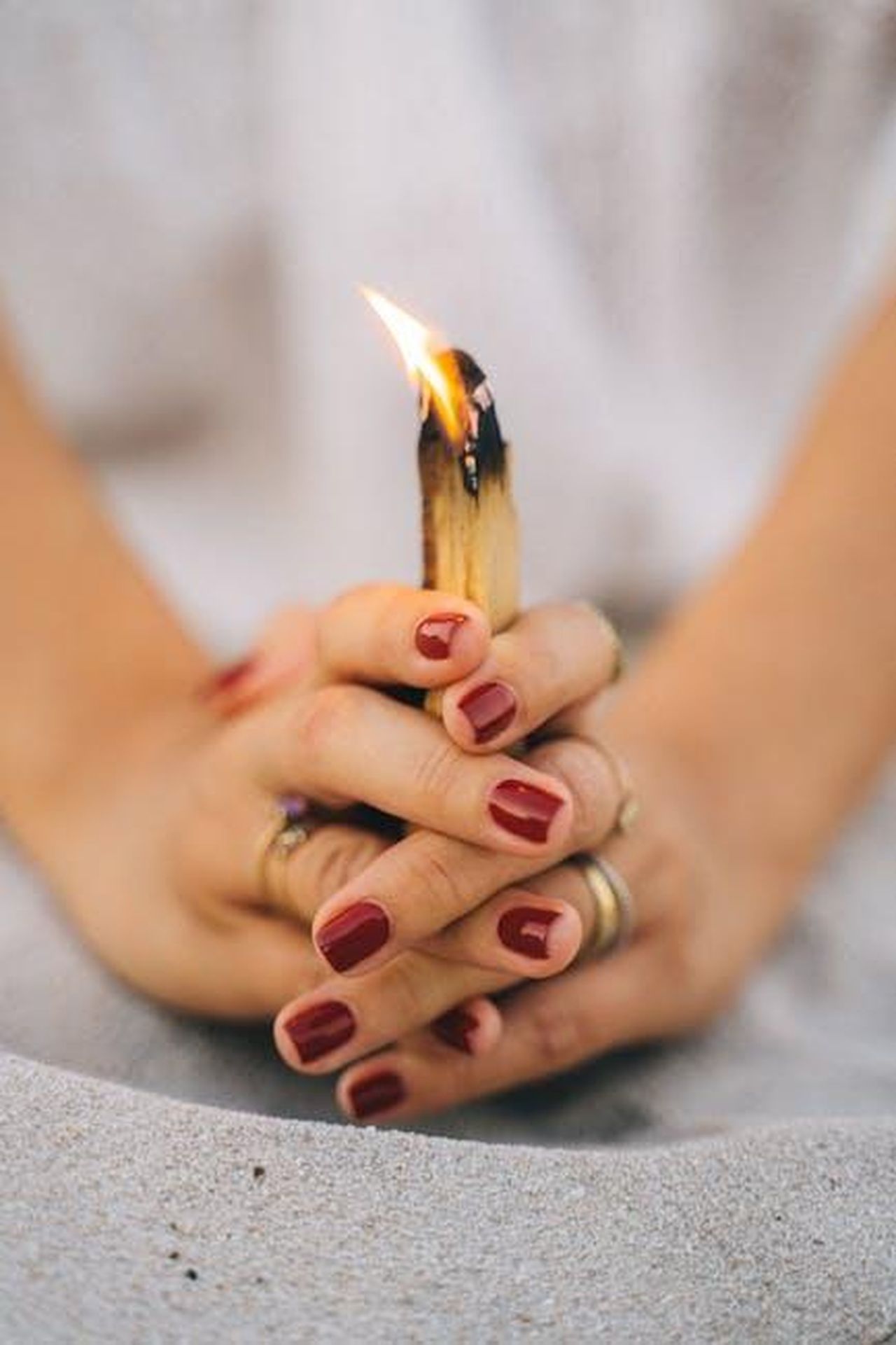 Segni_di_Fuoco_Ariete_Leone_Sagittario_TGeBxwglV7 - Confidenze24 Source: Anna Tarazevich - pexels - Close-up of hands holding burning Palo Santo for spiritual meditation.