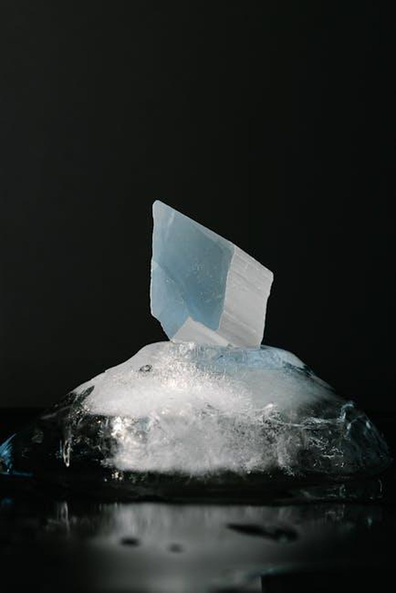 Simboli_di_Acqua_Cancro_Scorpione_Pesci_5xNUxRojyh - Confidenze24 Source: Mikhail Nilov - pexels - A shard of blue crystal emerging from a melting block of ice against a dark backdrop.