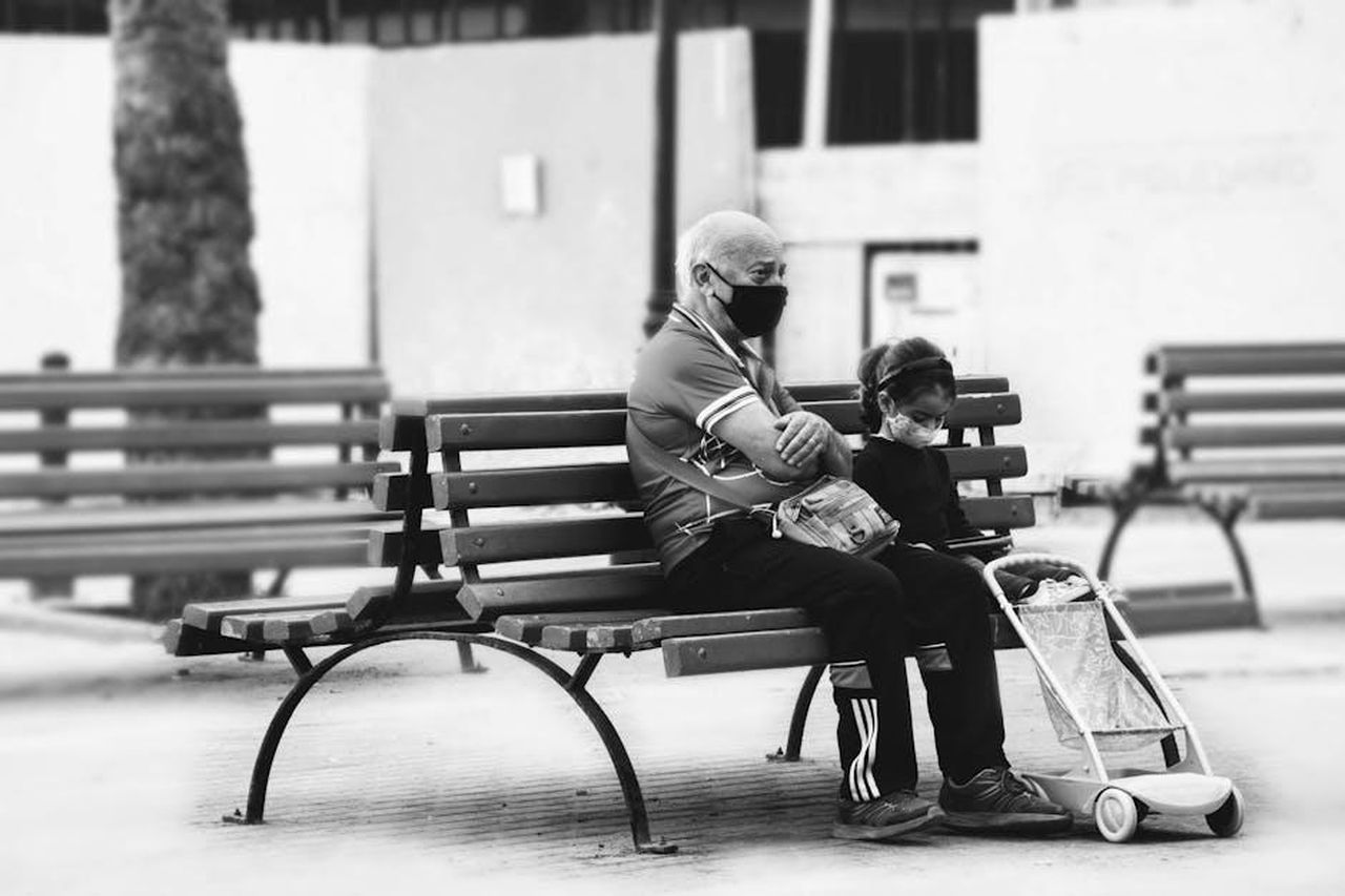 Stefania_Orlando_ha_confessato_di_non_voler_assecondare_la_coinquilina_QdC636XcSl - Confidenze24 Source: Danny Doneo - pexels - An elderly man and child sit on a bench wearing masks, capturing a COVID-19 moment.