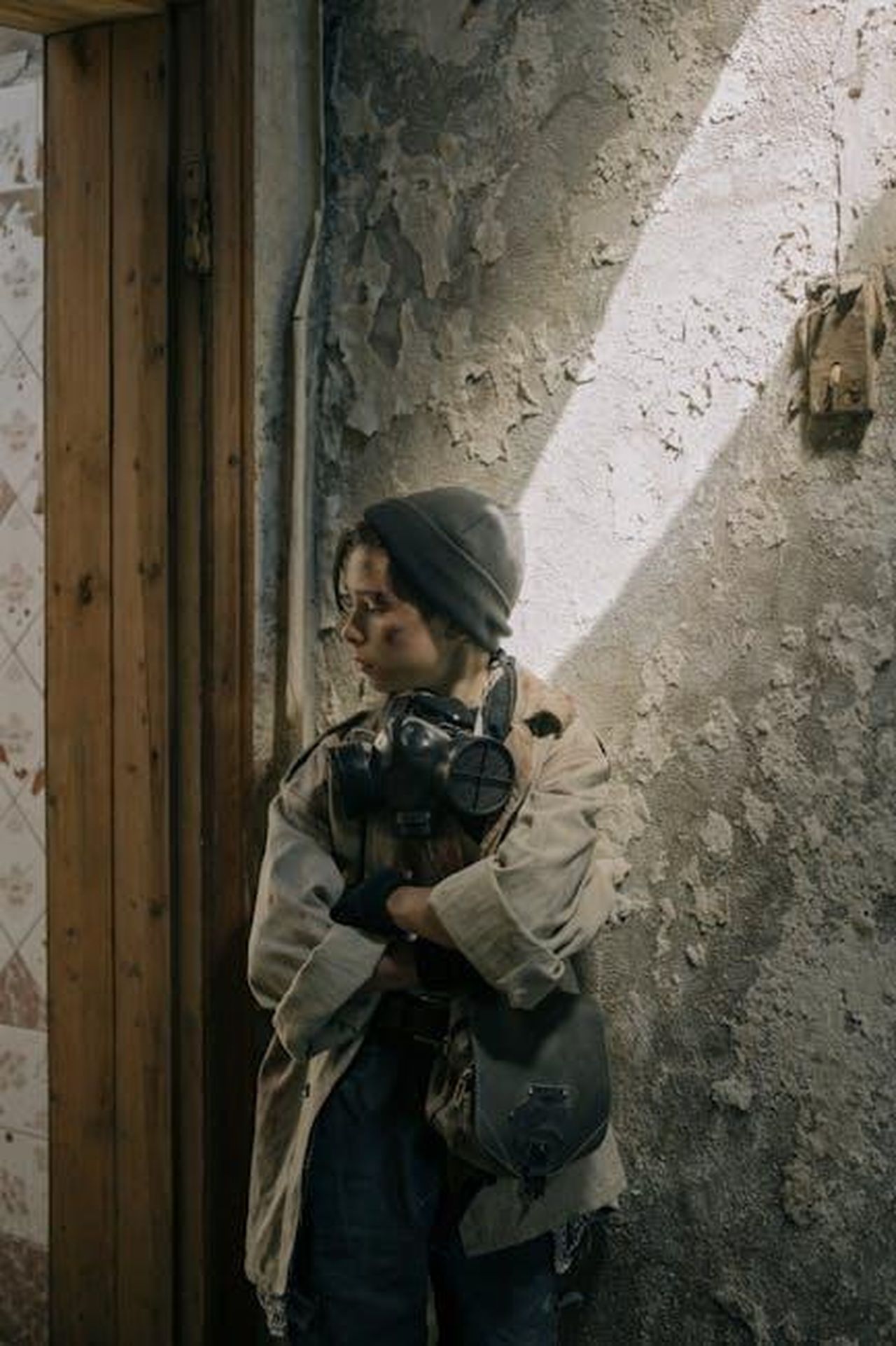 Stefania_interviene_il_confronto_si_accende_89wyTqgQwb - Confidenze24 Source: cottonbro studio - pexels - A young person in a post-apocalyptic setting leaning against a damaged wall.