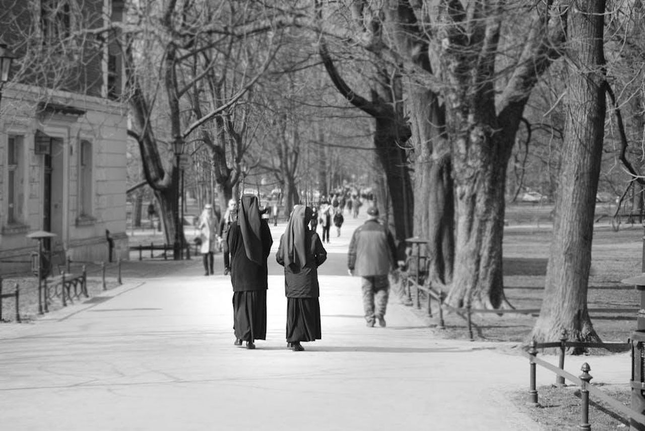 Suor_Azzurra_lascia_il_convento_anticipazioni_Che_Dio_ci_aiuti_8_prima_puntata_BxTX7ij2ic - Confidenze24 Source: Jade - pexels - Two nuns walking through a serene park in Kraków, depicting a peaceful and contemplative scene.