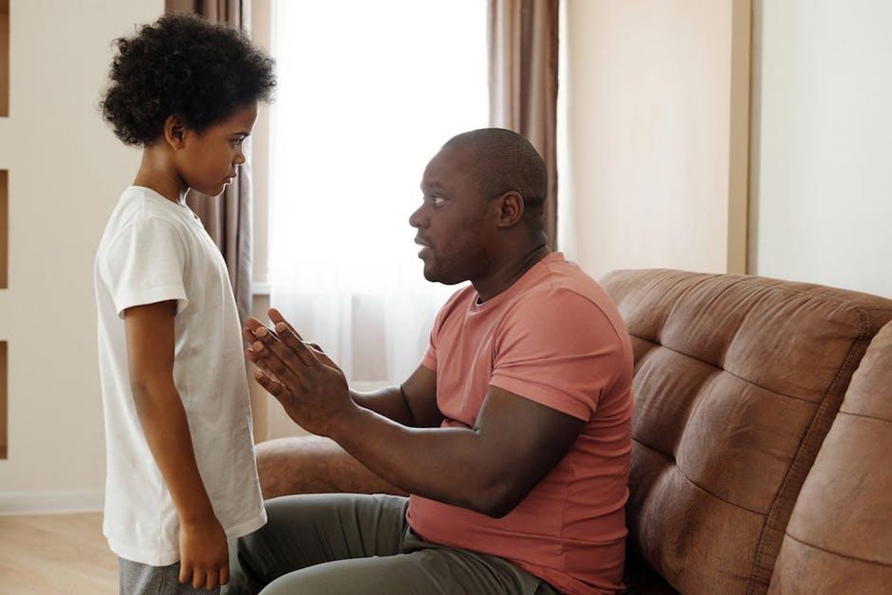 Superare_limbarazzo_come_affrontare_il_tema_con_i_figli_ZFAdkJR92Q - Confidenze24 Source: August de Richelieu - pexels - A father and son sharing an intimate conversation in a cozy living room setting.