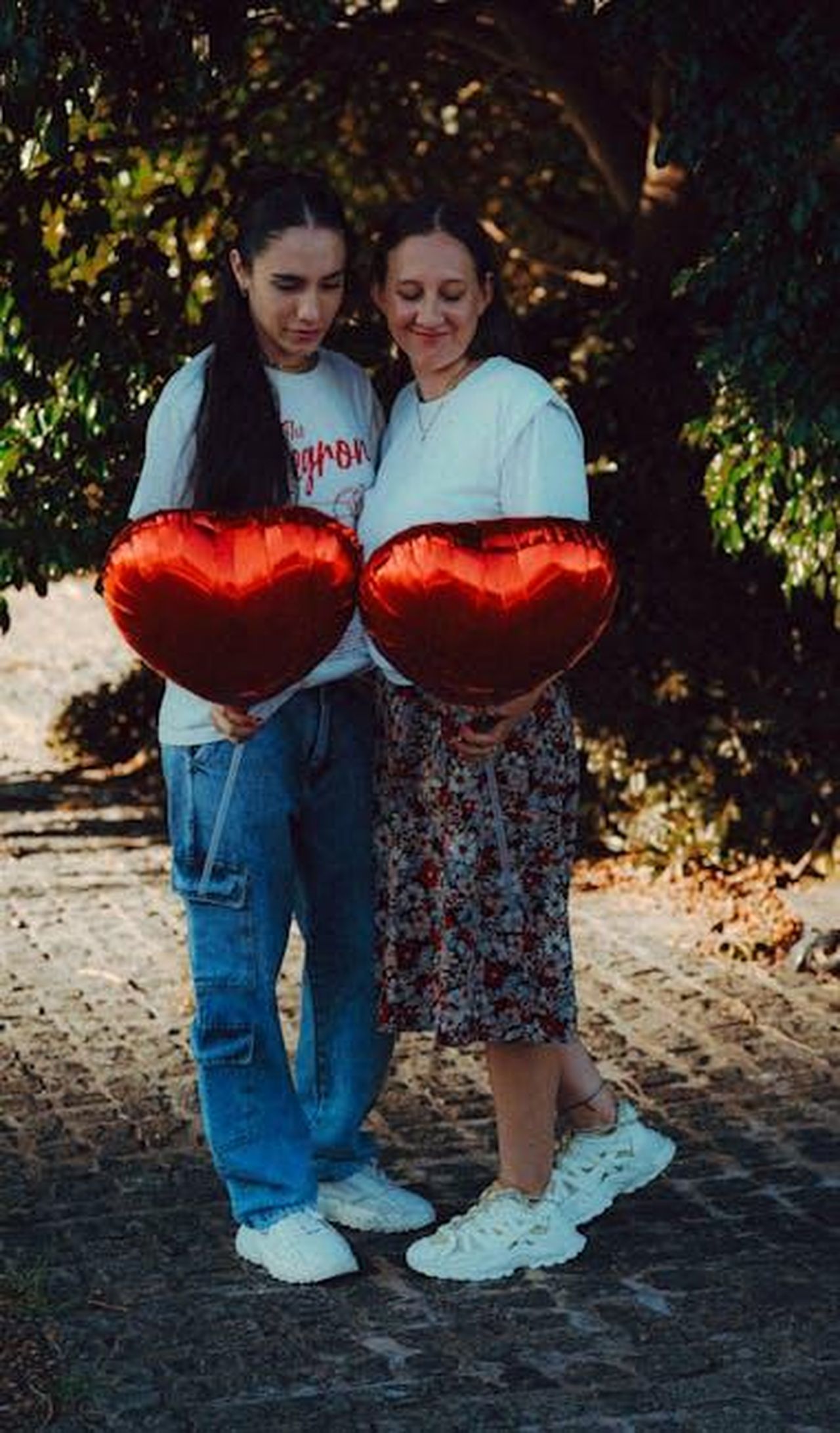 Supporto_Reciproco_e_Successi_Professionali_1jfyyRWqBR - Confidenze24 Source: Andres Idda Bianchi - pexels - Two adults holding heart balloons, captured in a serene outdoor setting.
