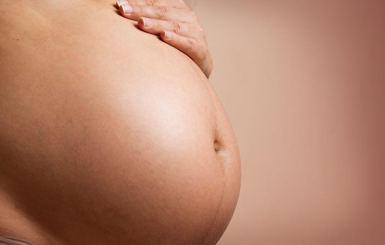 Supporto_dei_medici_e_speranza_di_un_miracolo_90ZMFNGAoE - Confidenze24 Source: Daniel Reche - pexels - An intimate close-up of a pregnant woman's abdomen, highlighting maternity and parenthood.