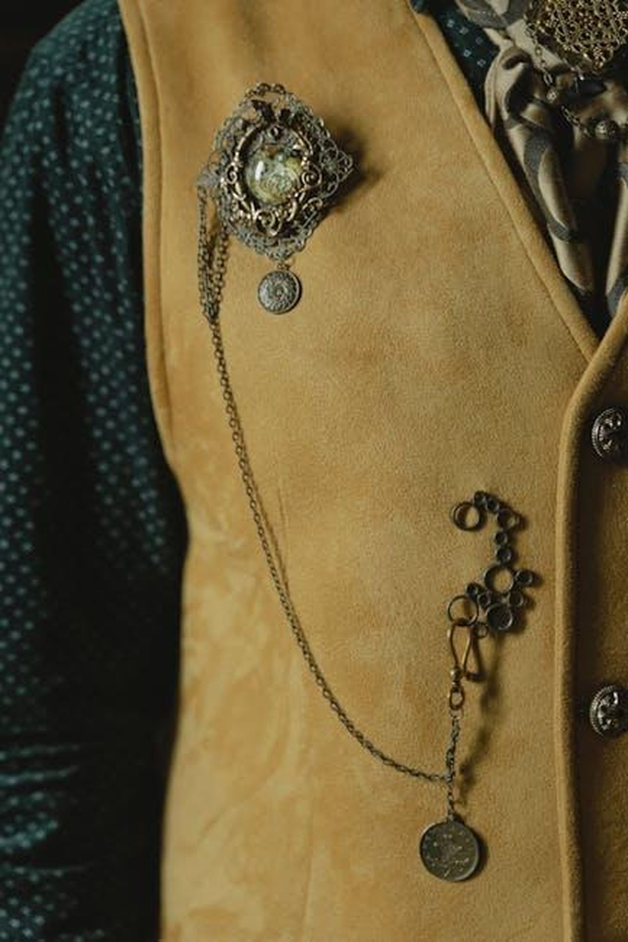 Svolgimento_del_game_show_QhBdth5Y2X - Confidenze24 Source: Tima Miroshnichenko - pexels - Close-up of a vintage vest adorned with chains and jewelry, creating an elegant and stylish look.