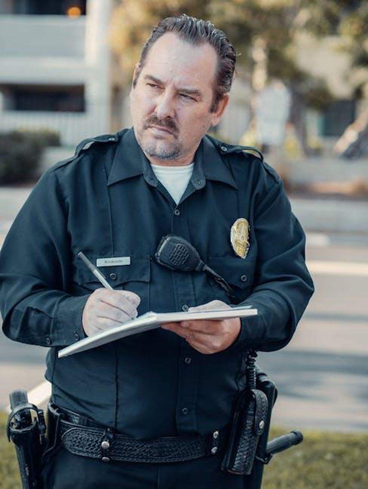 Tarik_denuncia_Umit_ma_Yesim_difende_il_fratello_di_Guzide_fnH8WI5SvC - Confidenze24 Source: Kindel Media - pexels - Police officer in uniform writing on notepad during daytime outdoors, showcasing community service.