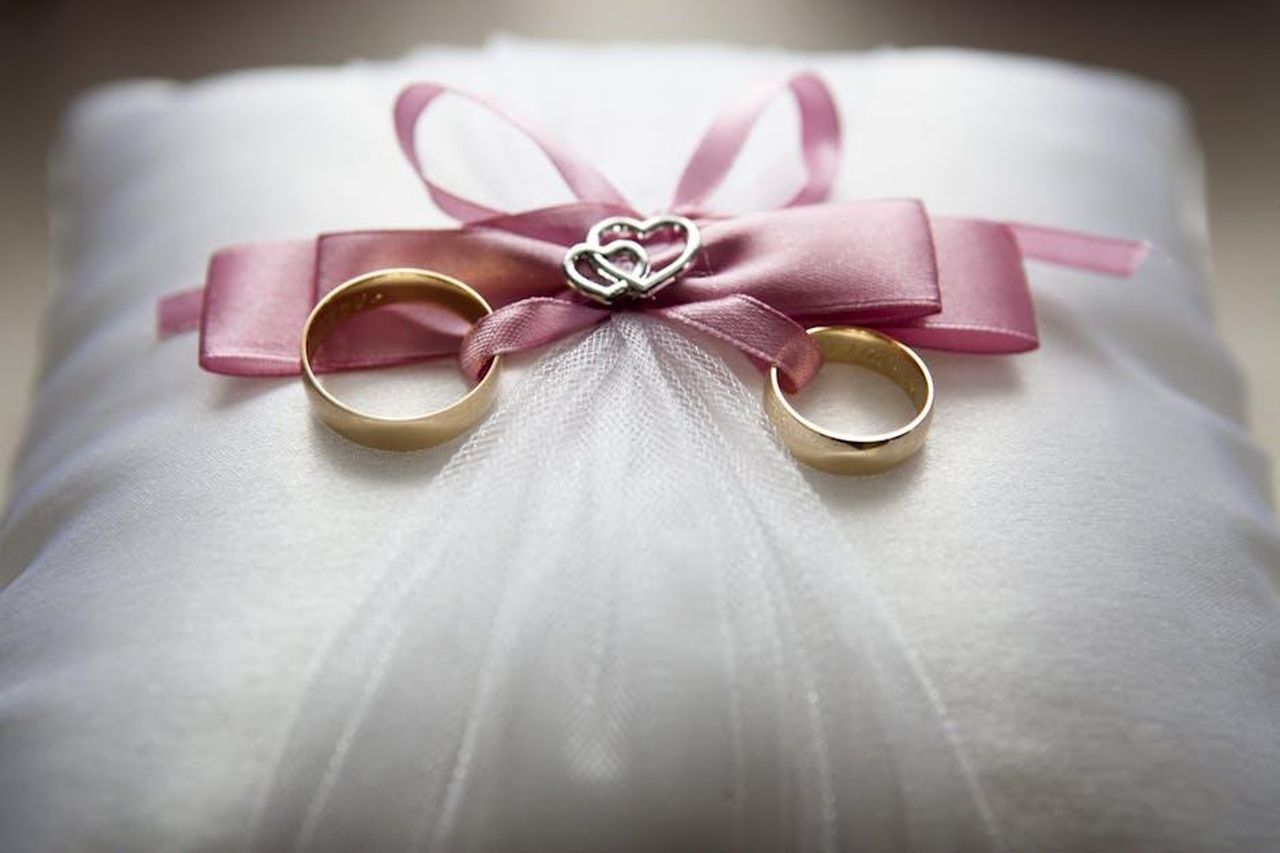 Tolga_chiede_la_mano_a_Oylum_dvjTy4q8Co - Confidenze24 Source: Pixabay - pexels - Close-up of elegant wedding rings on a silk pillow with a pink ribbon and a heart decoration, symbolizing love.