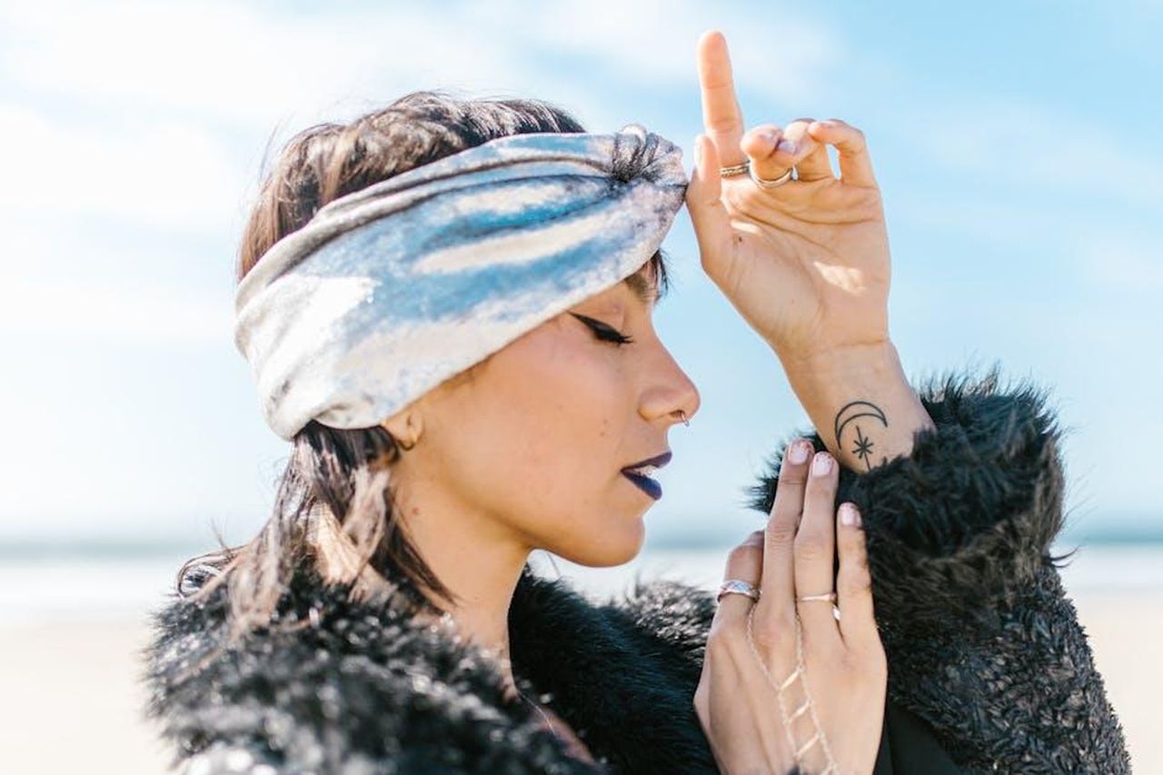 Toro__LL8mHnZNav - Confidenze24 Source: RDNE Stock project - pexels - Side profile of a fashionable woman with a celestial tattoo, embracing spirituality by the beach.
