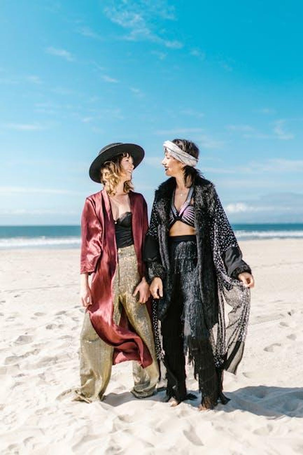 Toro_attenzione_in_amore_e_lavoro_Rl3xSDcBHD - Confidenze24 Source: RDNE Stock project - pexels - Two women in bohemian attire enjoy a sunny day at the beach, embracing a carefree vibe.