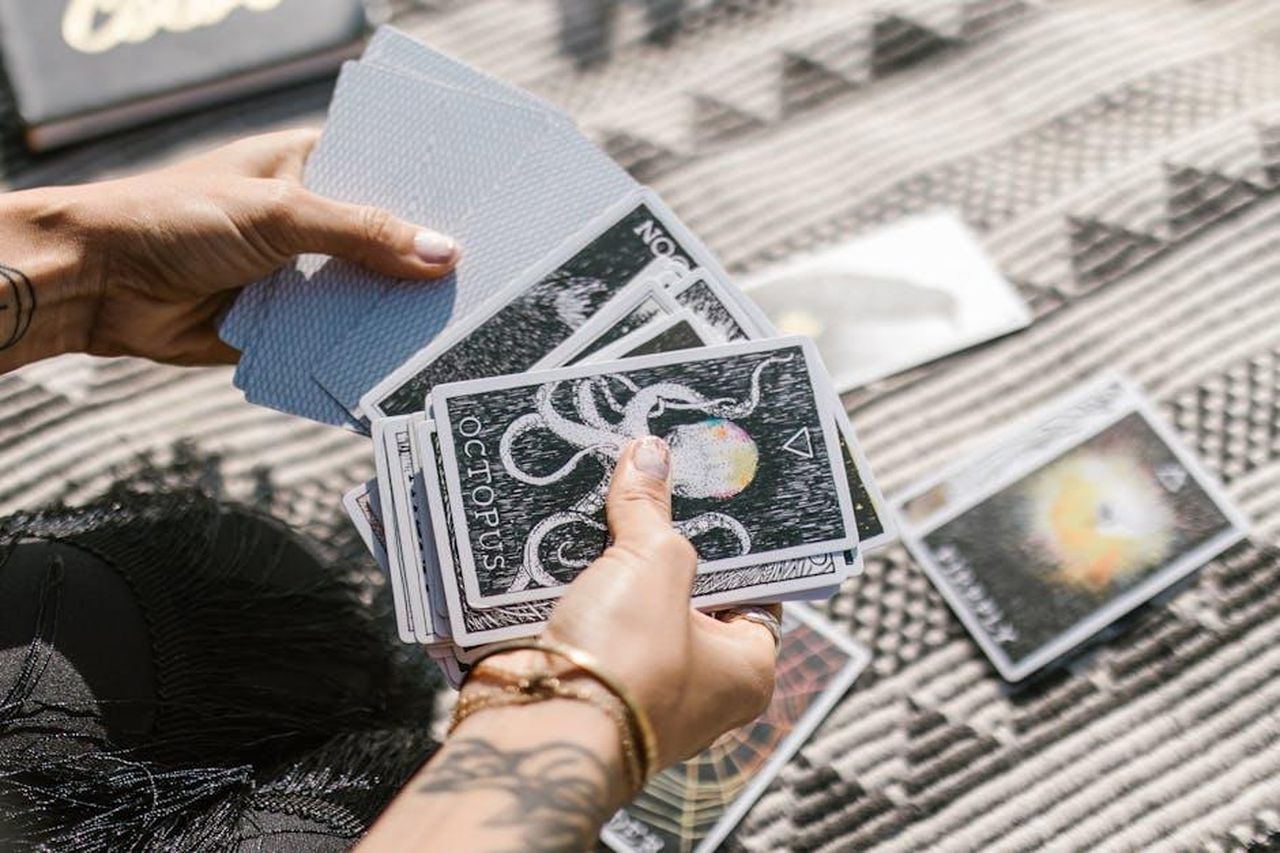 Toro_stabilit_sentimentale_eEdY4EvPIX - Confidenze24 Source: RDNE Stock project - pexels - Hands holding tarot cards during a reading session on a patterned mat.