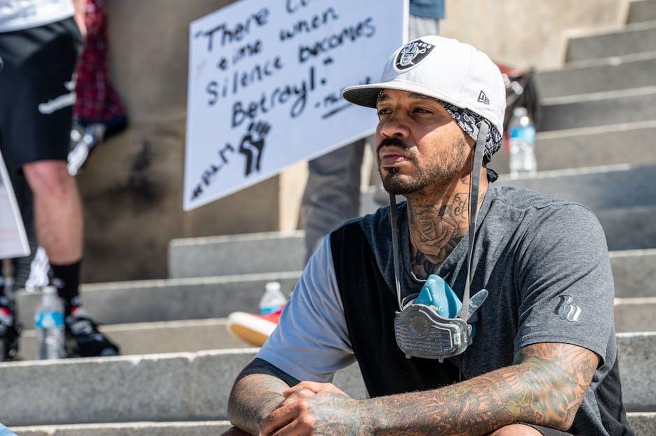 Trame_future_Tradimento_Yeim_scopre_linganno_di_Burcu_jGjVtTPVO1 - Confidenze24 Source: Brett Sayles - pexels - A thoughtful man sits on stairs during a peaceful protest, wearing a mask and displaying tattoos.