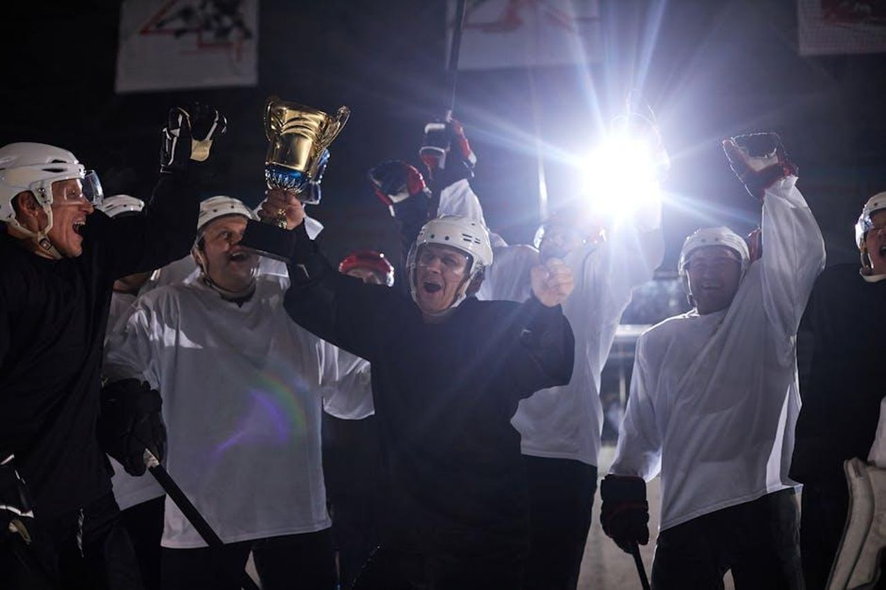 Tre_italiane_su_quattro_fuori_dalla_Champions_MWIySzLnAp - Confidenze24 Source: Tony Schnagl - pexels - A joyful hockey team celebrates victory holding the trophy on the ice rink.