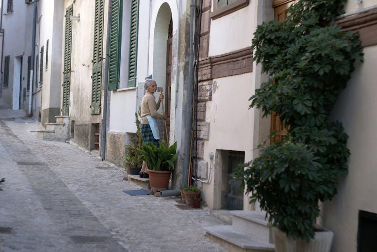 Unamicizia_distrutta_la_rottura_tra_Zeudi_e_Mattia_lzTyh0DD6k - Confidenze24 Source: Roman Biernacki - pexels - Charming narrow alley in Grottammare, Italy, featuring a local resident and vibrant greenery.