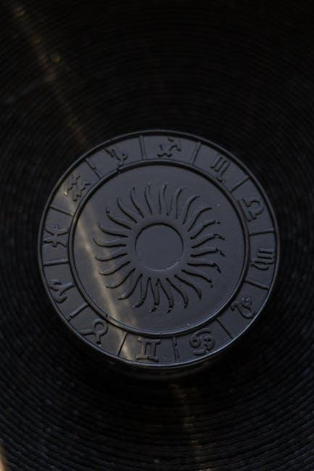 Vergine_cambiamenti_significativi_c42QEbXzec - Confidenze24 Source: Ann Bugaichuk - pexels - Embossed round lid featuring zodiac signs around a central sun symbol, creating a decorative aesthetic.