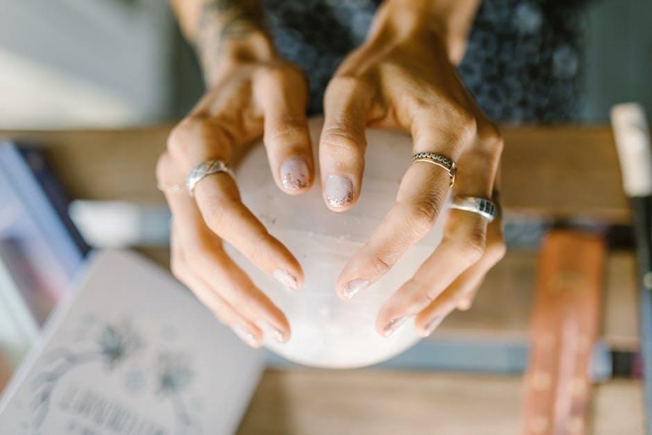 Vergine_iniziativa_e_riconoscimenti_dMRQvRqCZO - Confidenze24 Source: RDNE Stock project - pexels - Hands wearing rings holding a crystal sphere, symbolizing spirituality and healing.