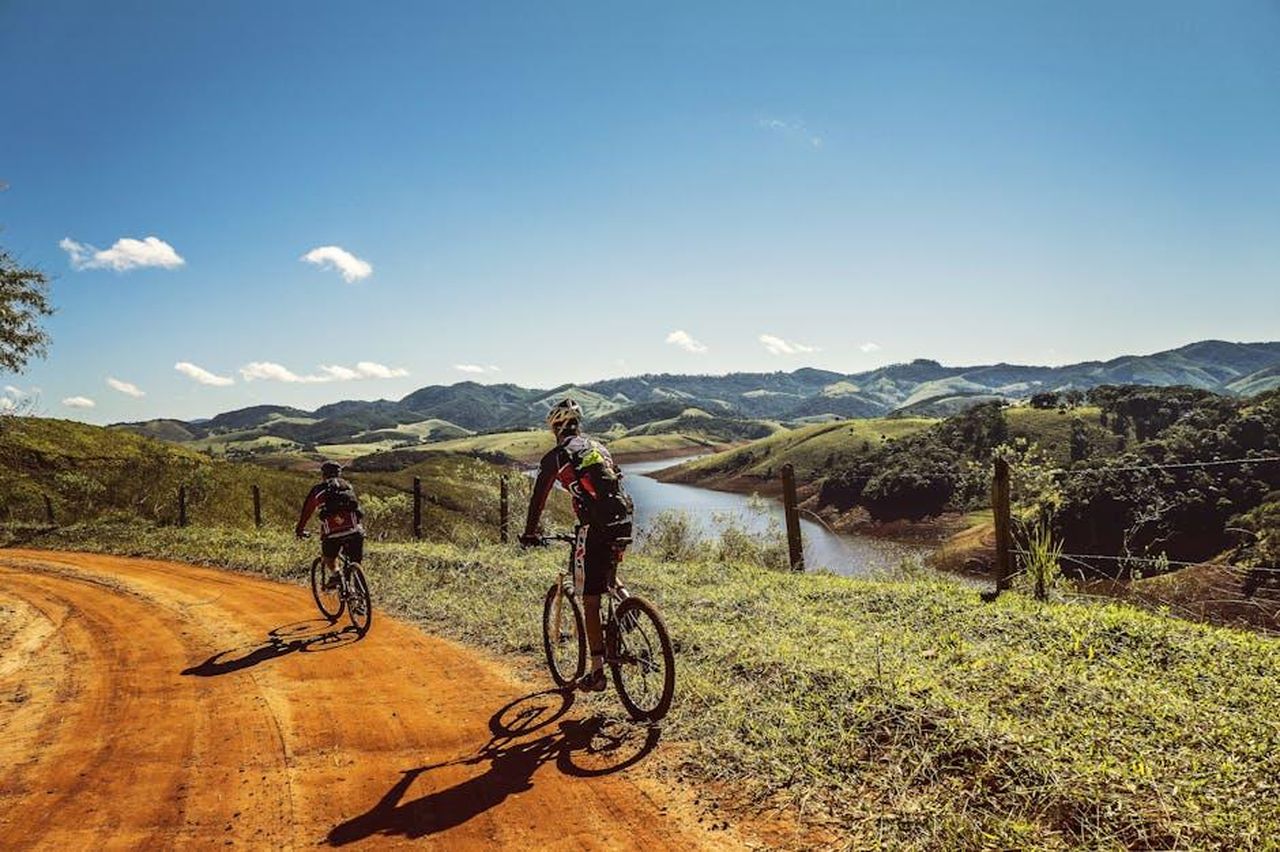Vingegaard_Il_Tour__lobiettivo_principale_35x5EC4gwA - Confidenze24 Source: Pixabay - pexels - Two cyclists riding on a dirt trail with stunning mountain views and clear skies.