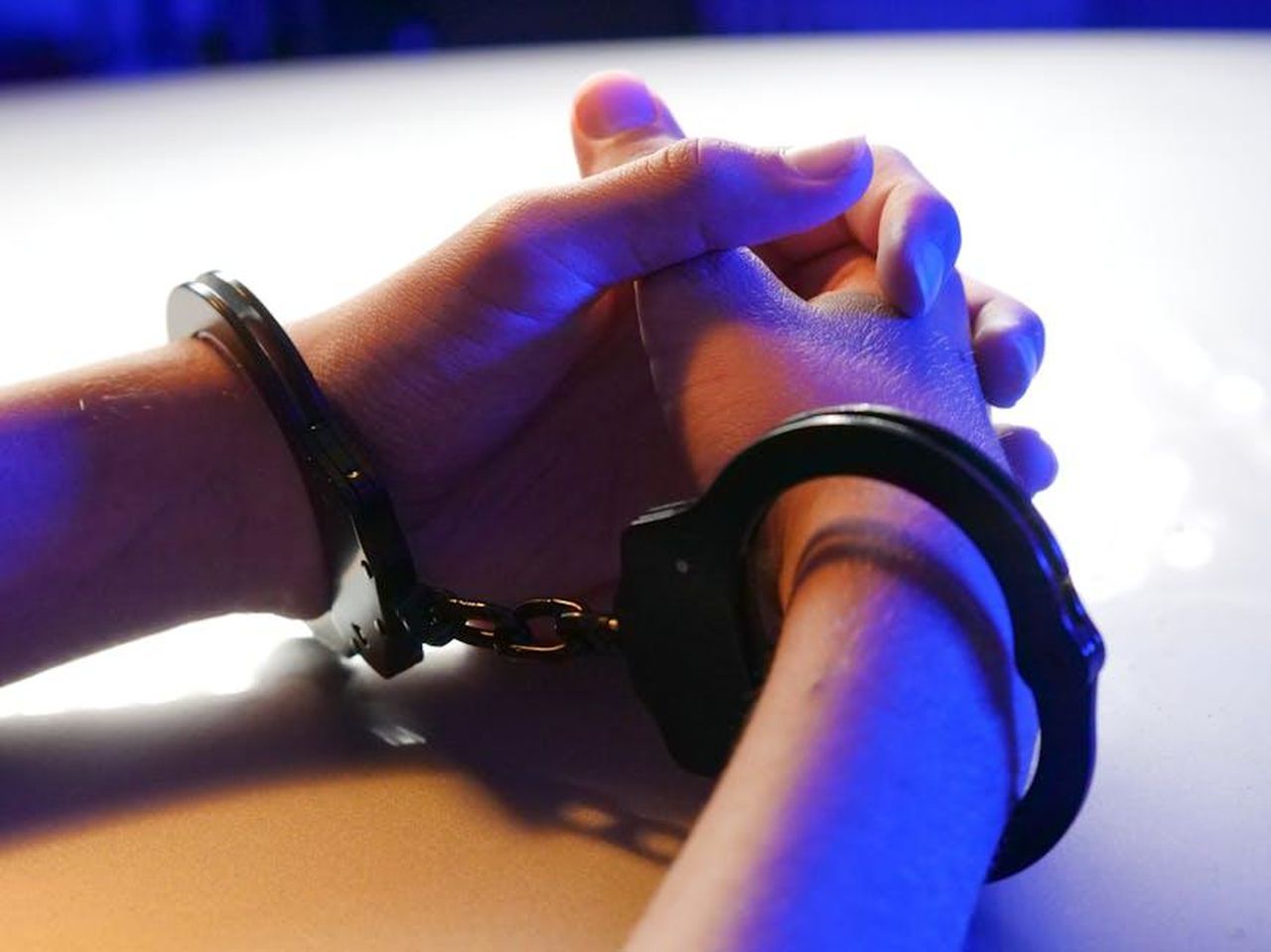 Yeim_accusa_mit_di_rapimento_e_la_polizia_lo_arresta_sIFMi0piAx - Confidenze24 Source: Kindel Media - pexels - Close-up of handcuffed hands under blue police light, signifying arrest or detention.