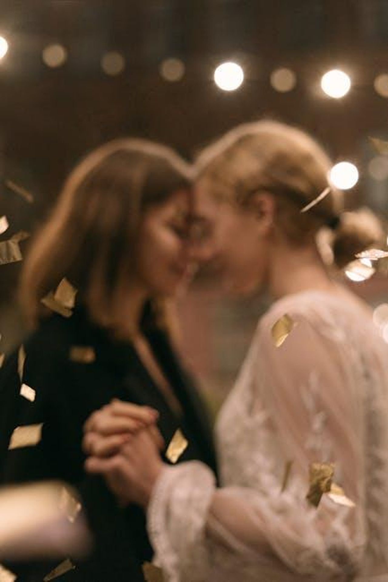 Zaya_parla_della_sua_vita_amorosa_e_del_supporto_della_matrigna_BUpFZKwMrl - Confidenze24 Source: Ivan Samkov - pexels - A romantic dance between two women, surrounded by golden confetti at a party event.