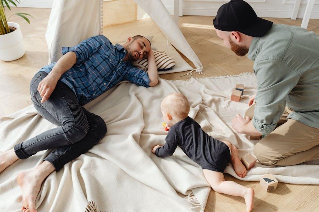 _nato_lamore_tra_Claudia_e_Giorgio_Gianmarco_Steri_inizia_a_fare_delle_scelte_7QOTODDpEz - Confidenze24 Source: Photo By: Kaboompics.com - pexels - A family spending quality time indoors, featuring a baby and two adults engaging in play.