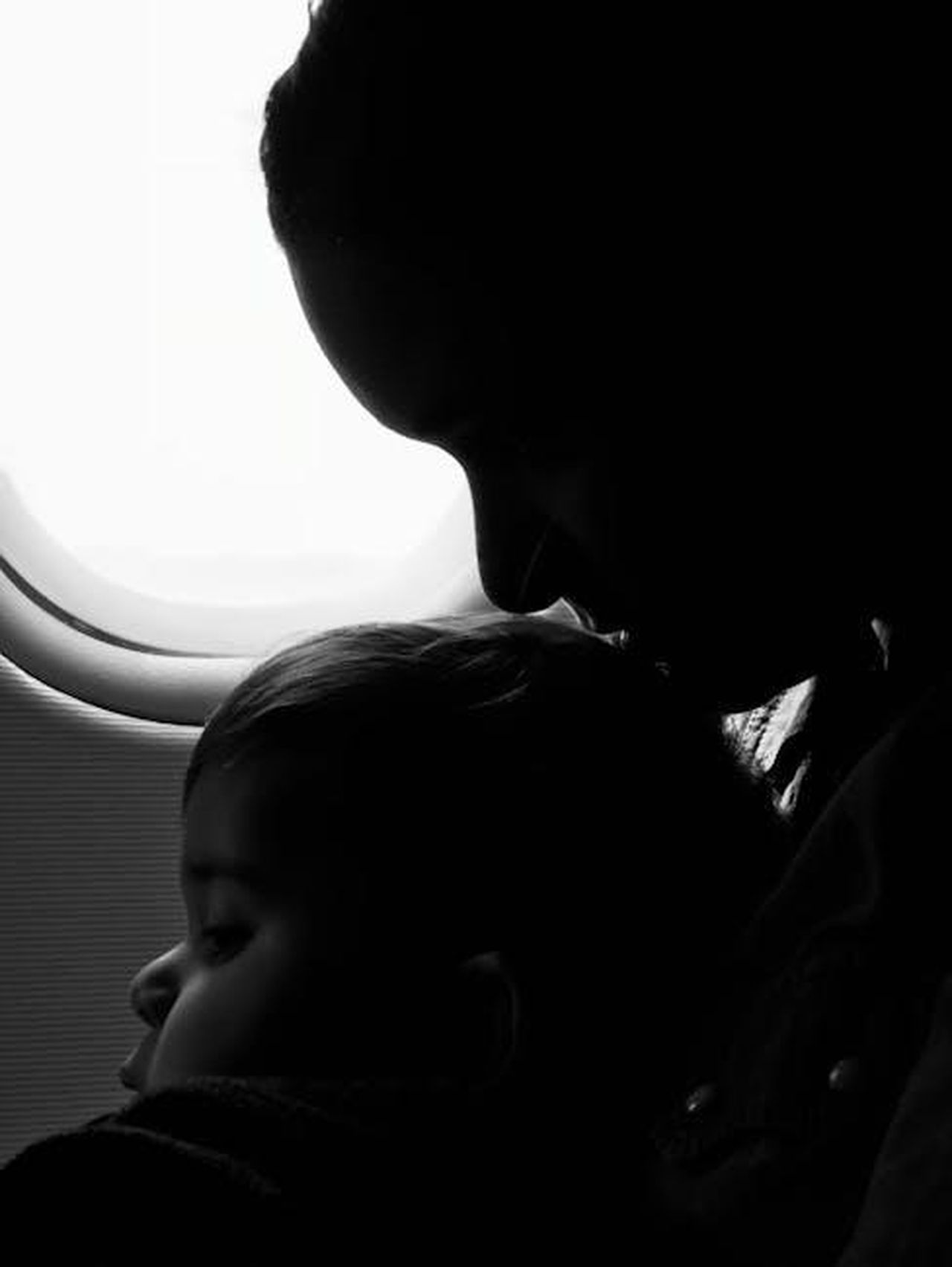 yk_trova_conforto_in_Gzide_scatenando_la_gelosia_di_Yeim_xJouO3TvLB - Confidenze24 Source: Nicolas Postiglioni - pexels - Silhouette of a mother and child gazing out an airplane window during flight.