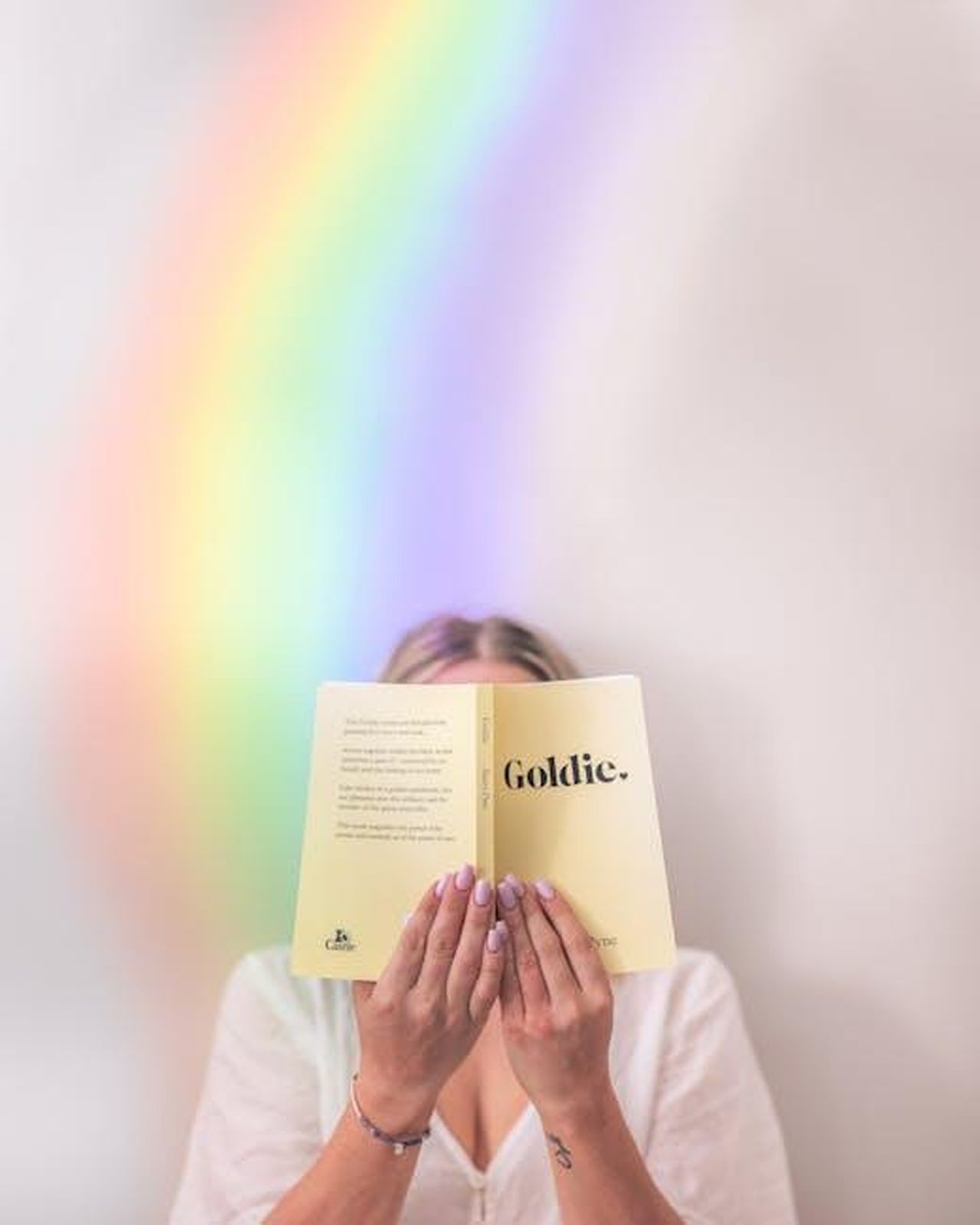 1987_Insieme_a_Kurt_Russell_6zKerD5NRO - Confidenze24 Source: Ben Mack - pexels - Unrecognizable female reading book in soft cover holding near face and standing near rainbow on background