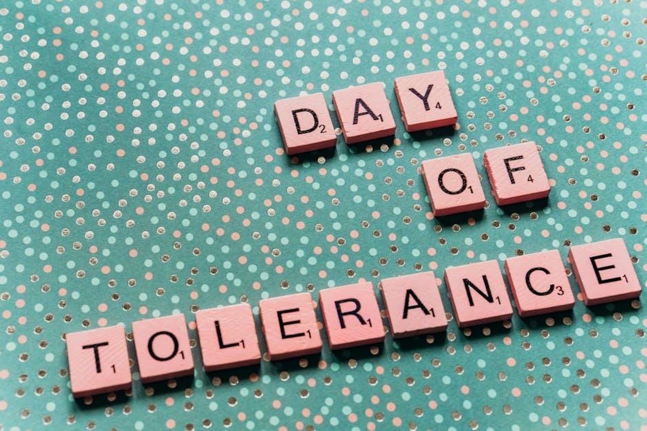 2_Usa_un_linguaggio_inclusivo_awppTVDR0Q - Confidenze24 Source: Alesia Kozik - pexels - Scrabble tiles arranged to spell 'Day of Tolerance' on a dotted teal background.