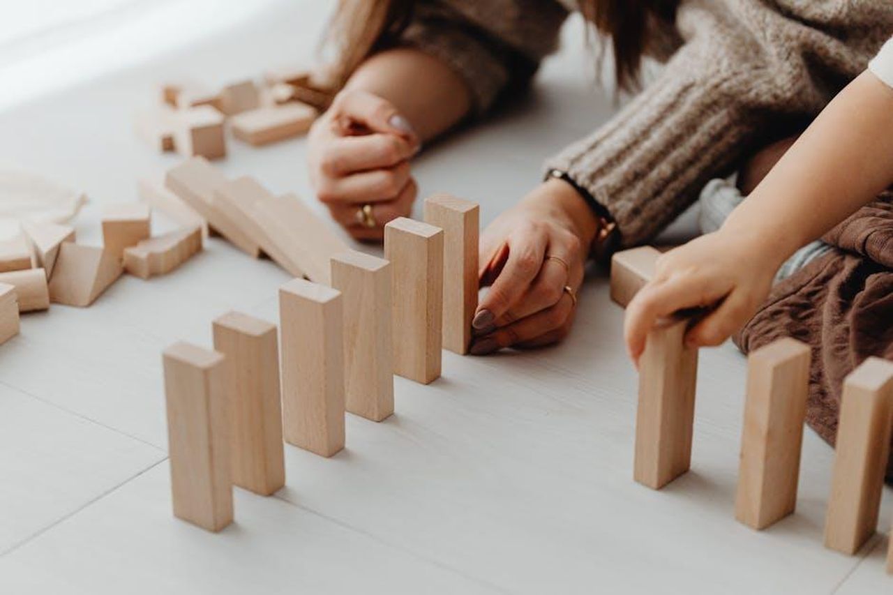 3_Non_fare_supposizioni_sullimpegno_dellaltro_genitore_4JcjLEXxYG - Confidenze24 Source: Photo By: Kaboompics.com - pexels - A child and parent engaging in creative play with wooden blocks indoors.
