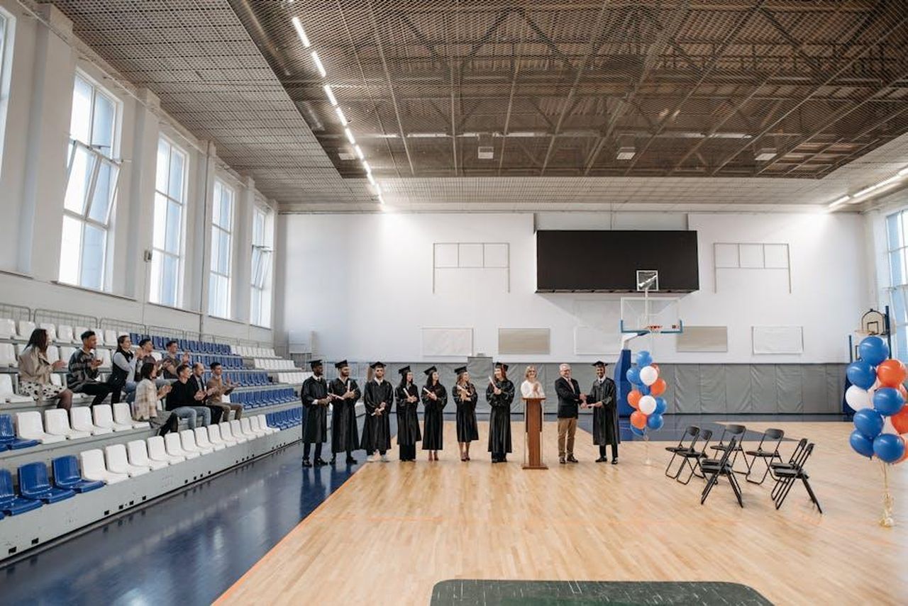 5_Gennaio_2025_Brody_dedica_un_premio_a_Chapman_YA1iy69V1K - Confidenze24 Source: Pavel Danilyuk - pexels - A graduation ceremony held in an indoor gymnasium with graduates and an audience.