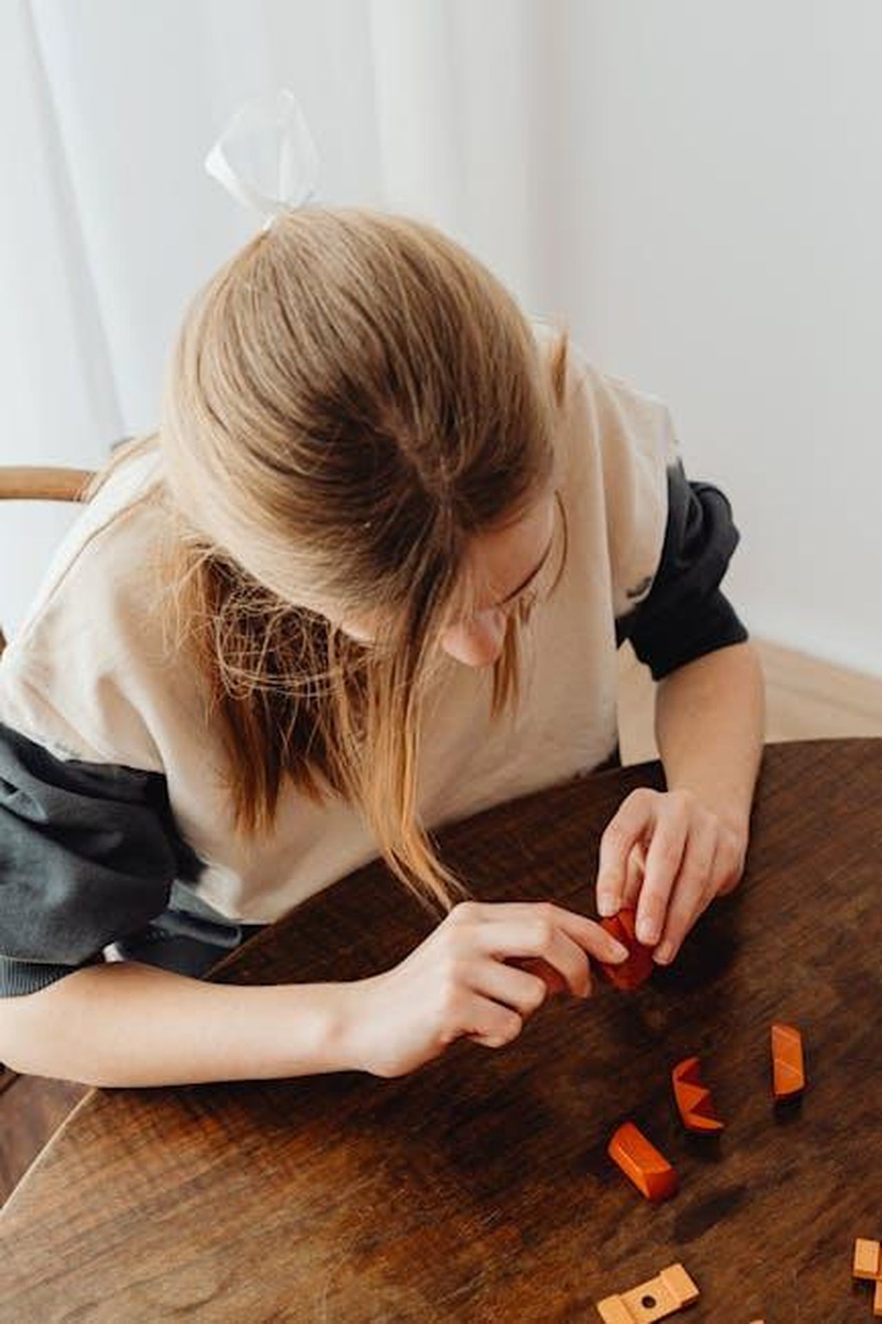 9_La_penetrazione_non__sempre_il_suo_gioco_preferito_yNrAnAW7pc - Confidenze24 Source: Photo By: Kaboompics.com - pexels - Girl playing with wooden blocks at home, enjoying creative playtime. Captured in high-angle view indoors.