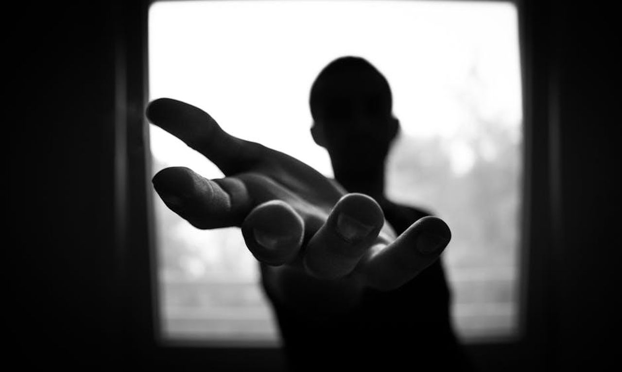 Accuse_di_traffico_di_esseri_umani_e_violenza_M23LzpnzZt - Confidenze24 Source: lalesh aldarwish - pexels - Silhouette of a hand reaching out in a black and white contrast.