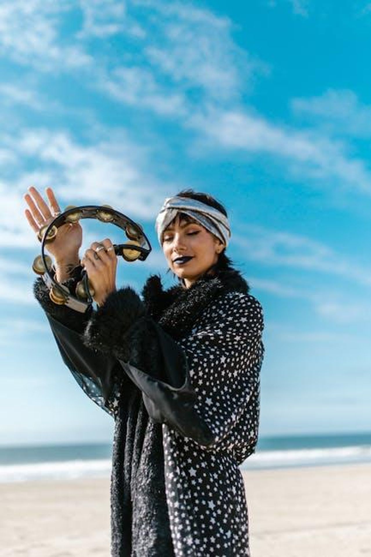 Acquario_20_Gennaio__18_Febbraio_p76wZGLozr - Confidenze24 Source: RDNE Stock project - pexels - A joyful woman with a tambourine on a sunny beach exuding bohemian vibes.