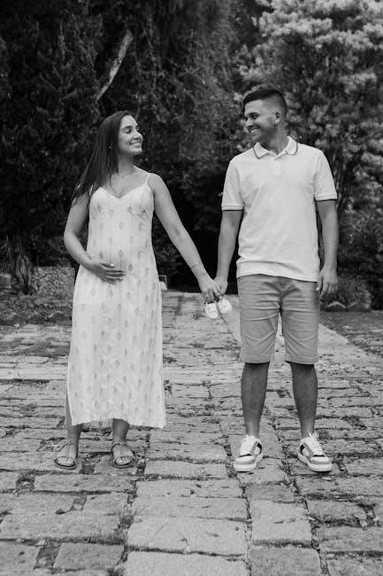 Aggiornamenti_dalla_vita_familiare_8JrNv24C3i - Confidenze24 Source: juliane Monari - pexels - Pregnant couple holding baby shoes, walking hand in hand on a cobblestone path.